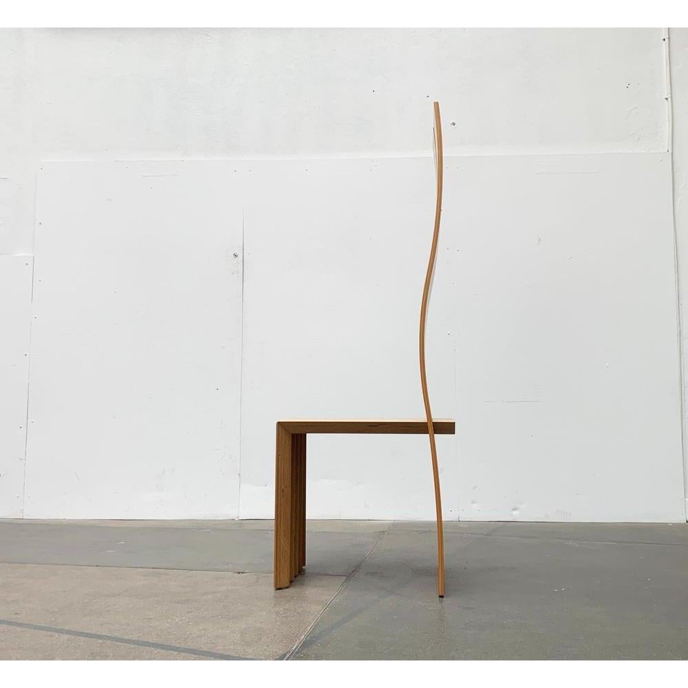 Postmoderner hoher Lehner-Stuhl.

Ein skulpturales Design in postmoderner Formensprache. Funktionaler Stuhl und imposantes Designobjekt. Das Design basiert auf der Durchdringung von zwei Elementen, der geschwungenen Rückenlehne und dem abgewinkelten