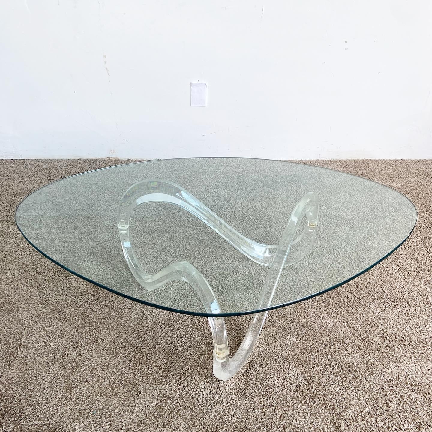Amazing vintage postmodern infinity lucite coffee table. Features a rounded triangle glass top which rests on a sculpted lucite base.