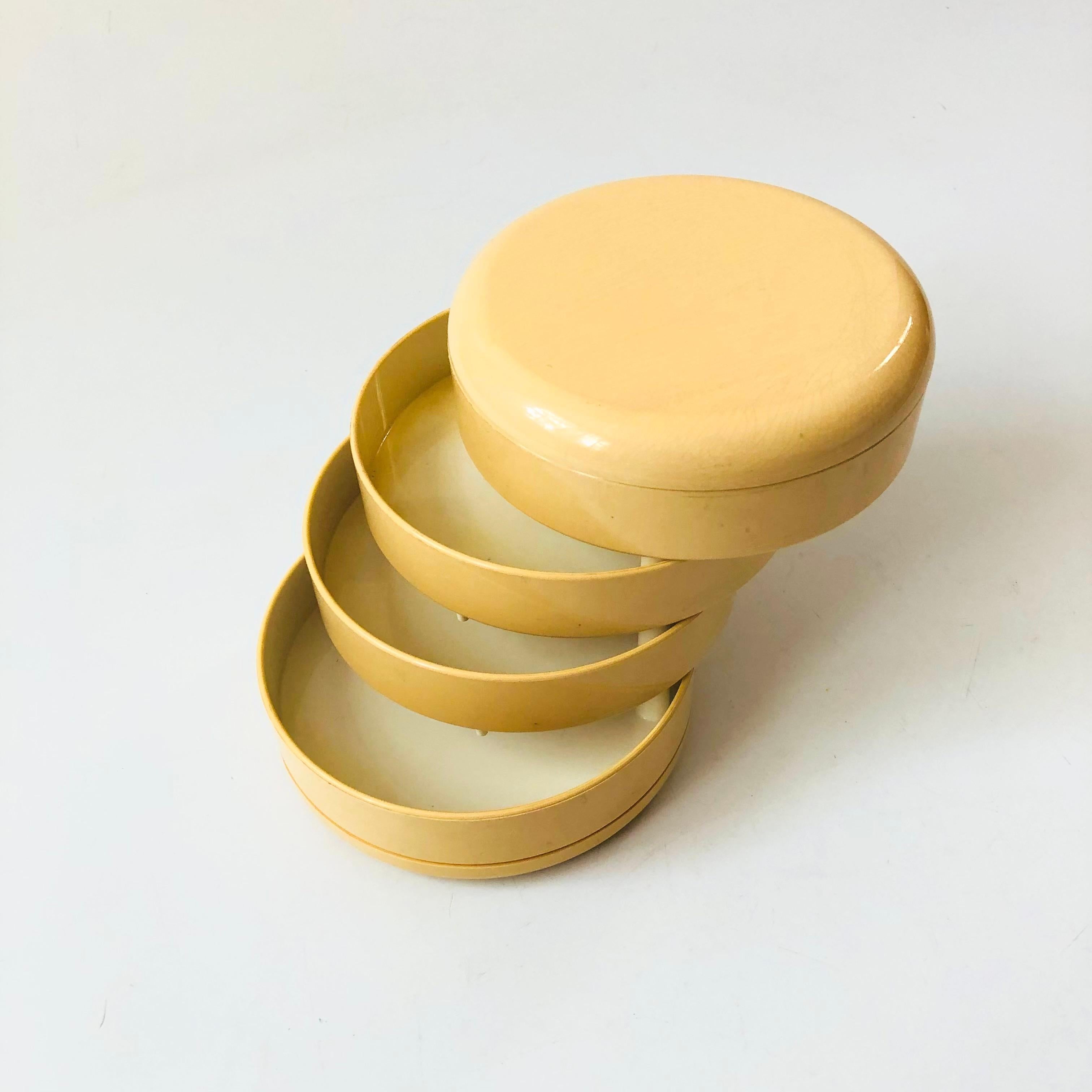 A vintage postmodern circular swivel organizer. 4 storage compartments swivel outwards for accessing small items and with a lidded top. Perfect for organizing desk or bathroom items. Cream colored plastic. Made by Interdesign.

