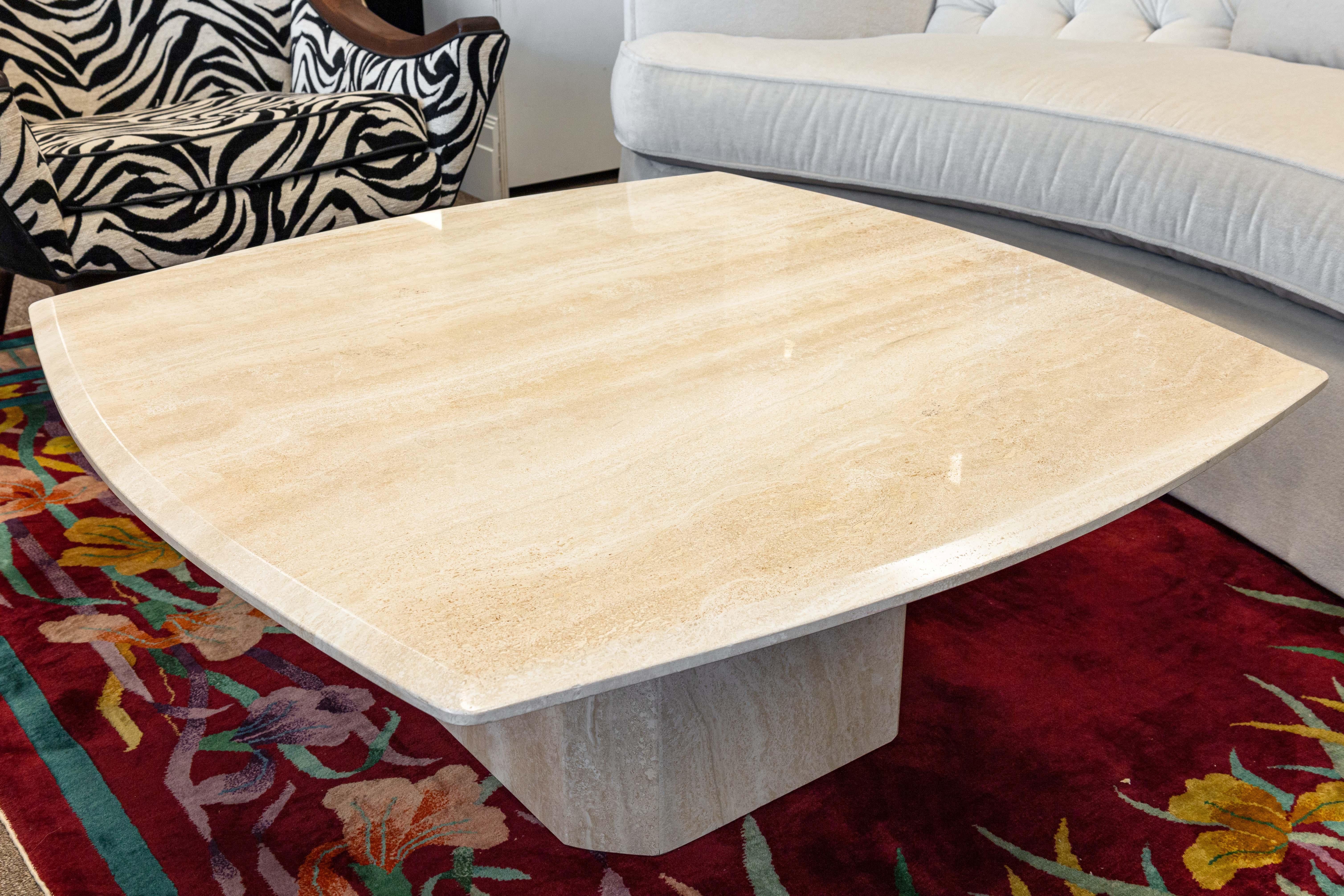 An Italian postmodern coffee table. This lovely coffee table features a lovely stone construction with a beautiful travertine marble material. The piece has a nice, glossy finish that has a lovely shine, while still retaining the gorgeous texture of
