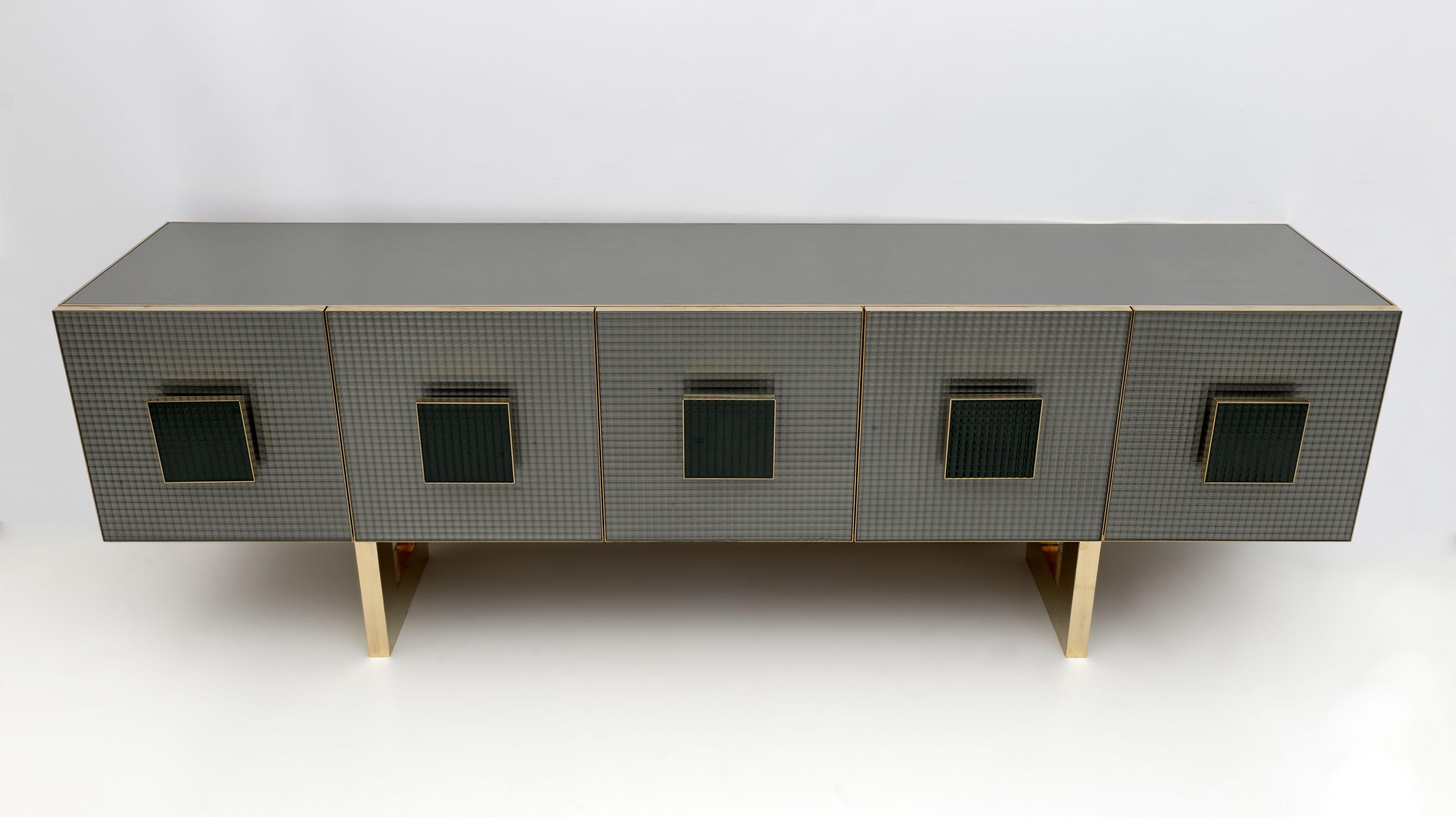 An interesting Postmodern sideboard / bar cabinet, of Italian design, with 5 gray printed glass front doors and square brass and dark green printed glass handles, highlighting the brass finishes. The rest of the cabinet, the top and the sides are