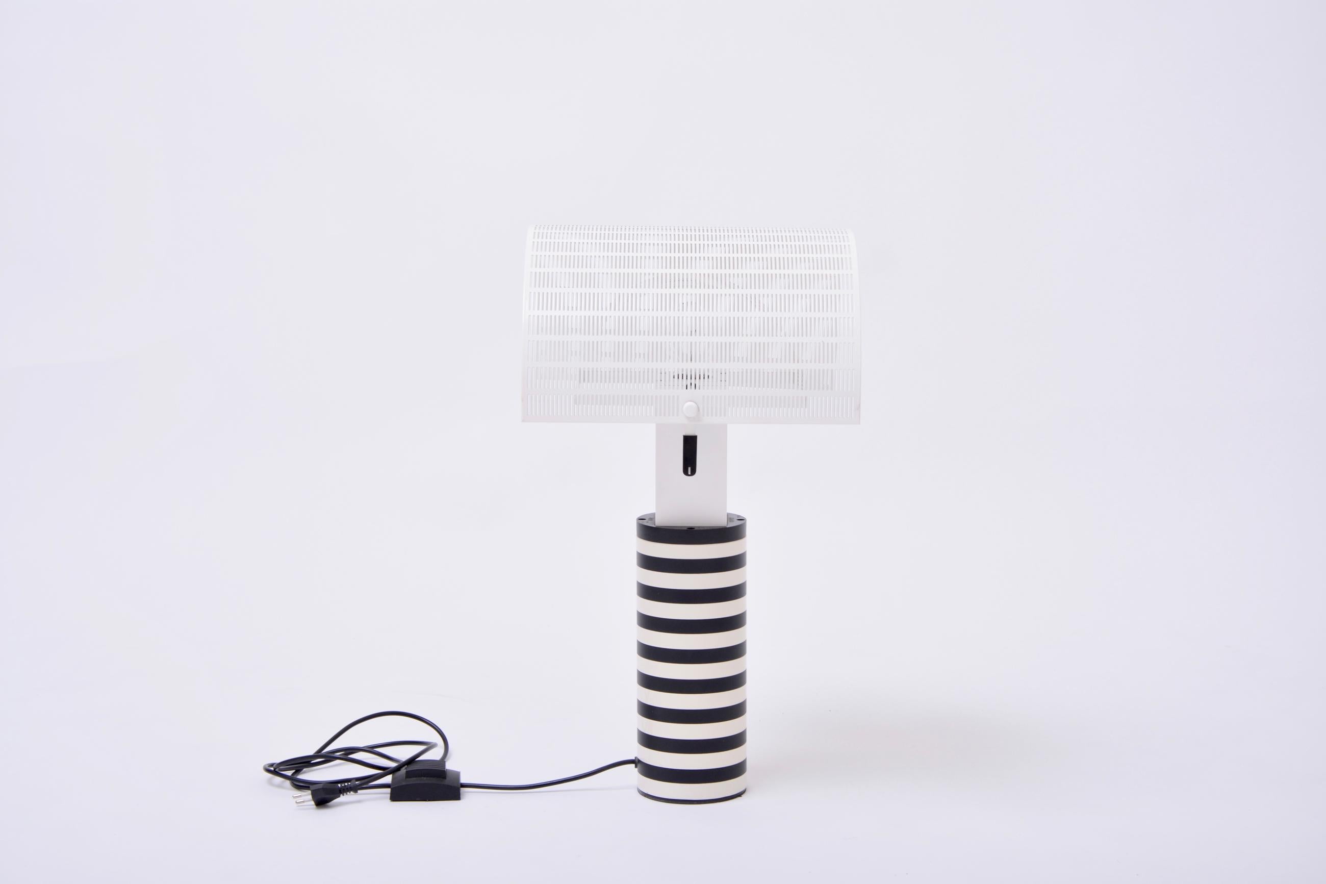 Postmodern Italian black and white table lamp 'Shogun' by Mario Botta for Artemide, 1986

A post modern table lamp by Mario Botta for Artemide. The cylindrical base made of powder coated cast iron features a bold black and white striped pattern. Two