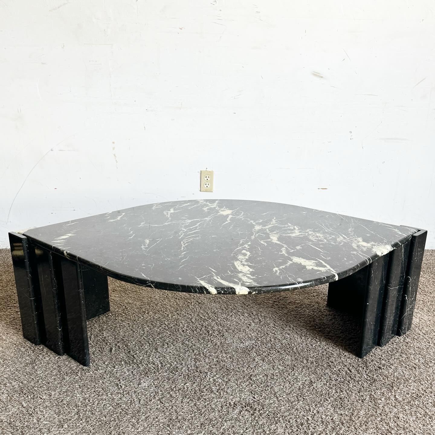 Embrace the bold aesthetics of postmodern design with this Italian Black Marble Tear Drop Coffee Table. Featuring a unique teardrop-shaped top crafted from luxurious black marble, this table embodies sleek sophistication. Its smooth, polished