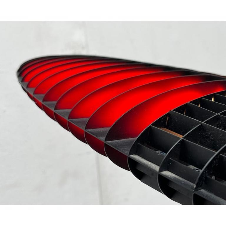 Der Leuchtenkörper besteht aus einem feinen Aluminiumrahmen als Reflektor, der einem Flügel nachempfunden ist. Die Lichtquelle befindet sich in der Mitte des Flügels.
Die Farbe der Lampe kann mit verschiedenen Farbfilterpaaren angepasst werden. Die
