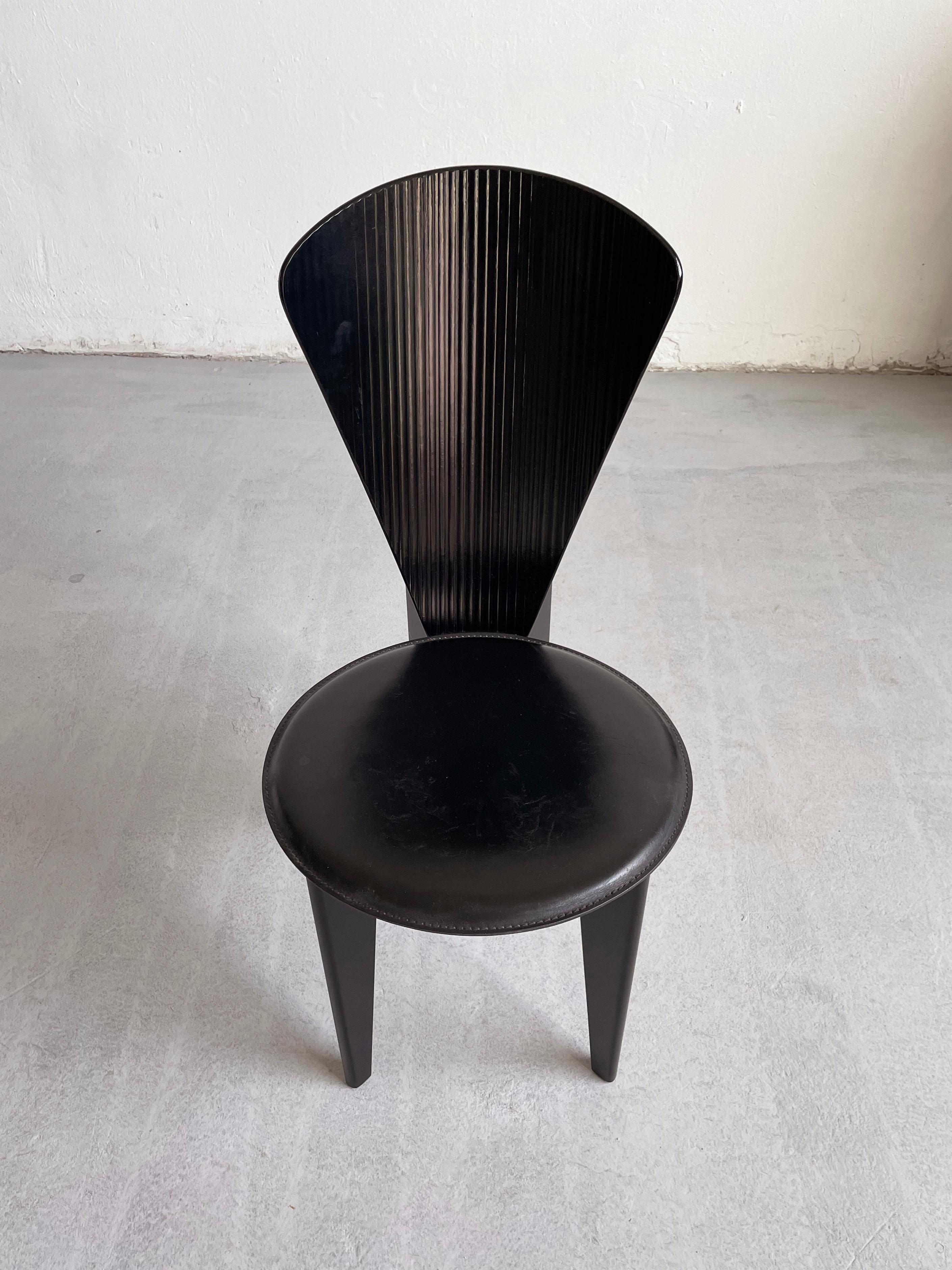 The black wooden dining chair by Calligaris was made in Italy, circa 1980.

Stunning sculptural postmodern design. The chair features a curved back with ridges and a round leather seat.

There are no structural issues. The leather seat has some