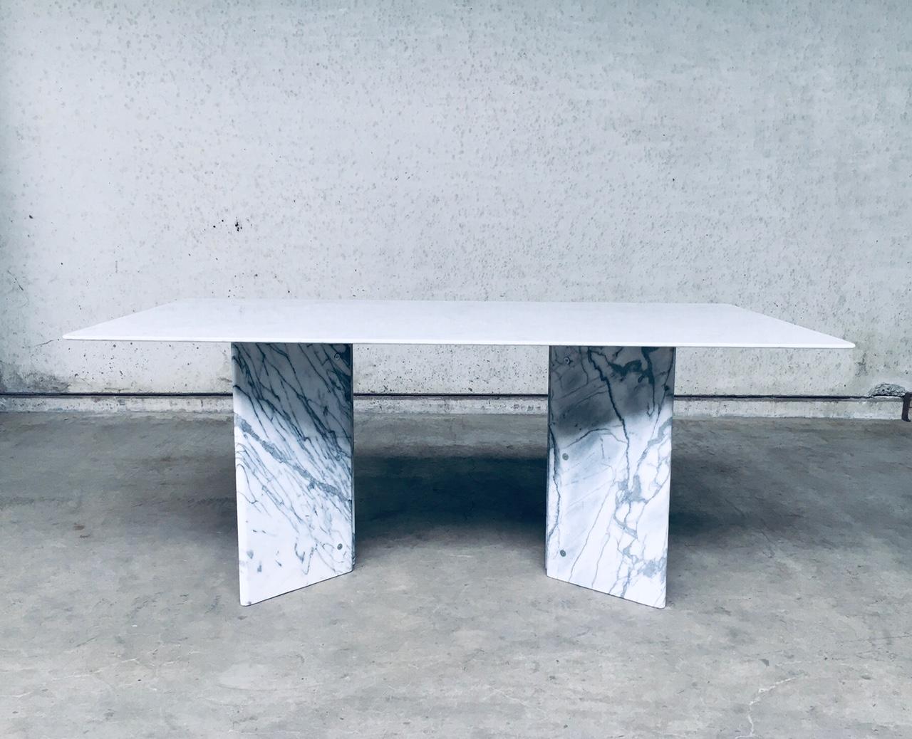 Vintage Postmodern Italian Design Carrara Marble Dining Table, made in Italy 1970's. No maker markings or designer found. Thin marble top on 2 V shape marble bases. Impressive dining table in very good condition. Table top has signs of use and some