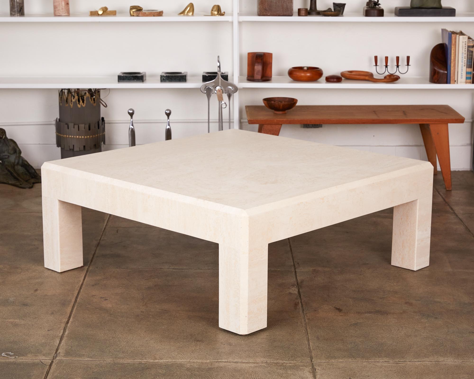 Postmodern travertine coffee table, Italy, circa 1970s. This square table has a thick travertine top, that sits atop four square column legs, featuring a chamfered edge detail. With a sleek shape that is reminiscent of tables designed by Italian