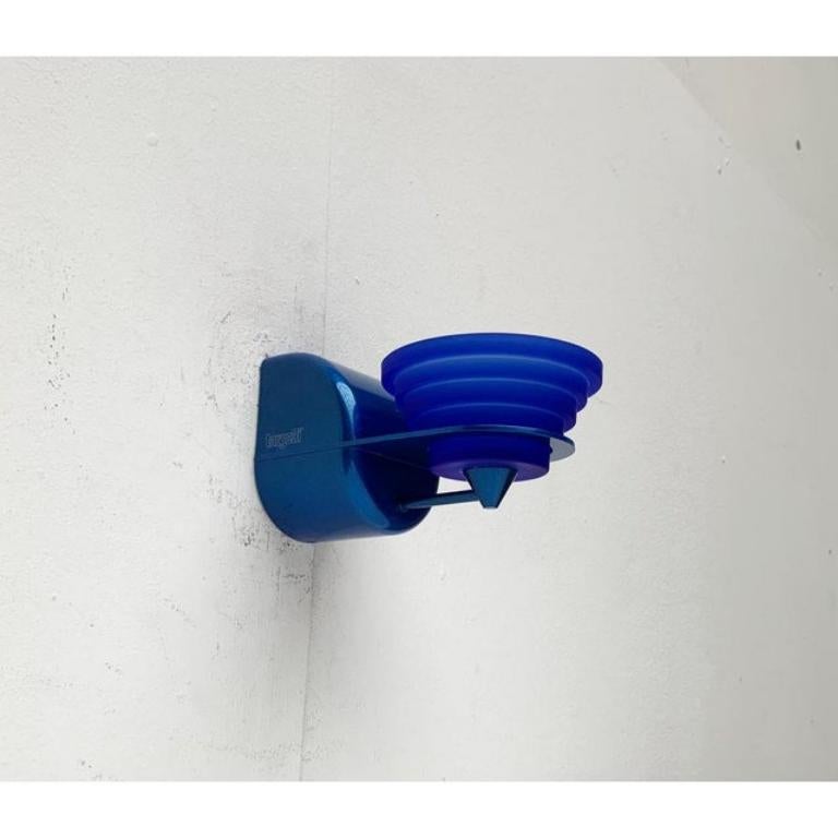 Seltene Wandleuchter des italienischen Herstellers Targetti.

Das Design folgt einer postmodernen Formensprache und Farbgebung. Die Leuchten sind einfarbig in Blau, mit einer anderen Farbe des Sockels und des Diffusors. Der Sockel besteht aus