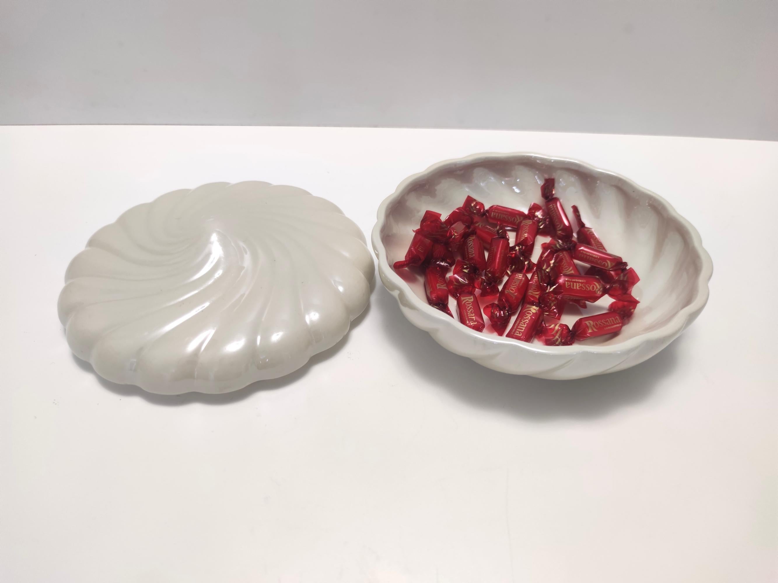 Made in Italy by Tommaso Barbi in the 70s. 
This trinket bowl / vide-poche is made in glazed porcelain. 
It might show slight traces of use, but it can be considered as in excellent original condition and ready to become a piece in a home.
