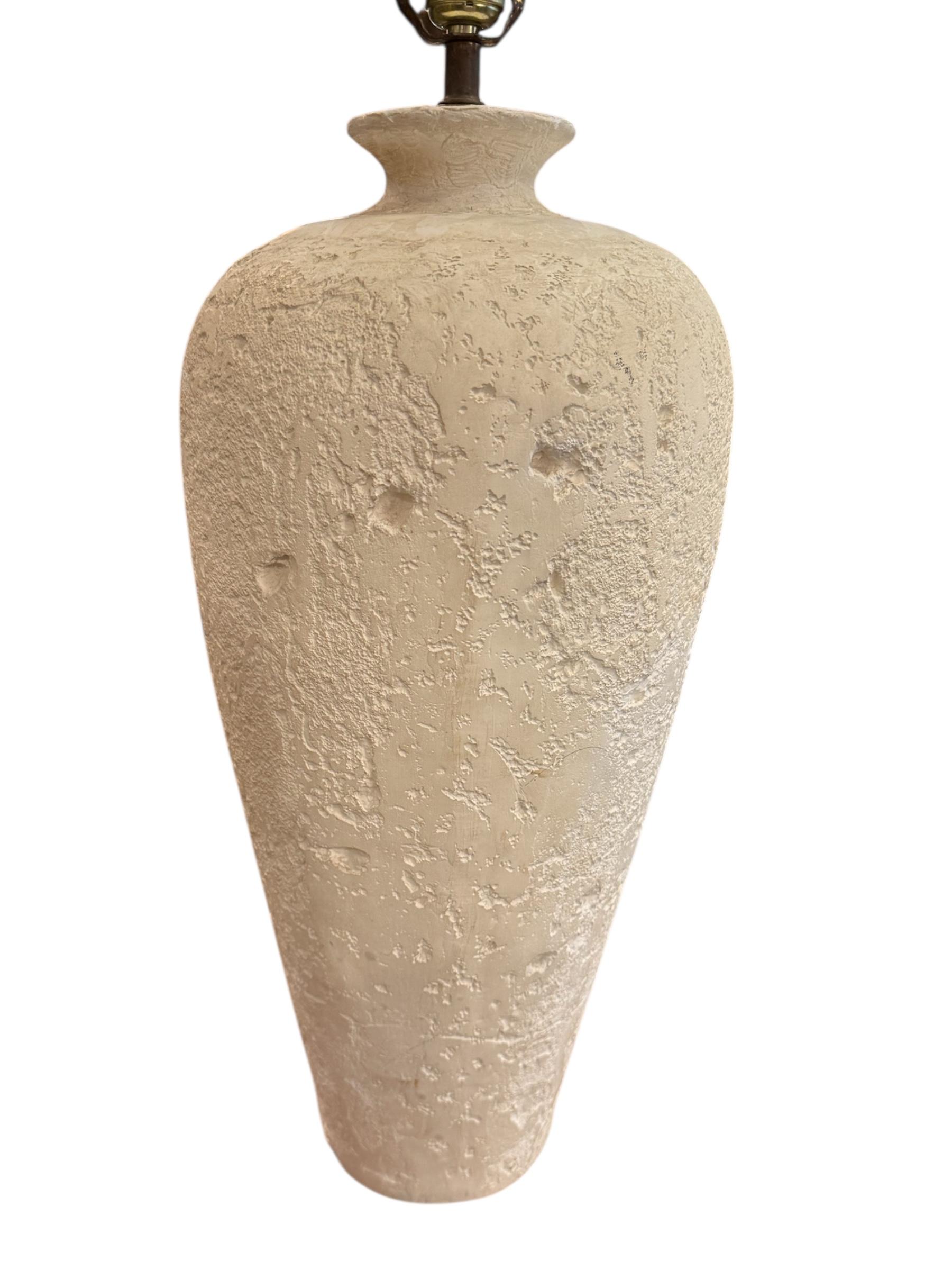 Bring sculptural simplicity and contemporary charm into your space with this Postmodern Ivory Textured Pottery Table Lamp. Featuring a tall, slender form with a natural plaster-like surface, the lamp blends minimalist design with tactile detail. Its