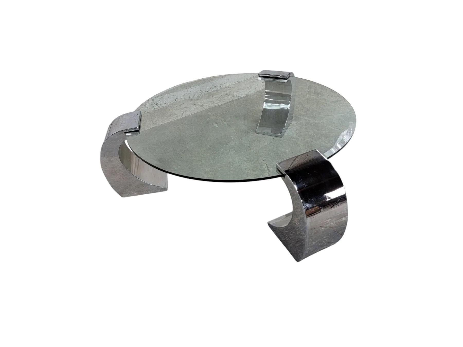 Table basse postmoderne de style Karl Spinger, grande table ronde en verre biseauté à 3 pieds cantilever chromés.

Un superbe design postmoderne avec des pieds tripodes de style 