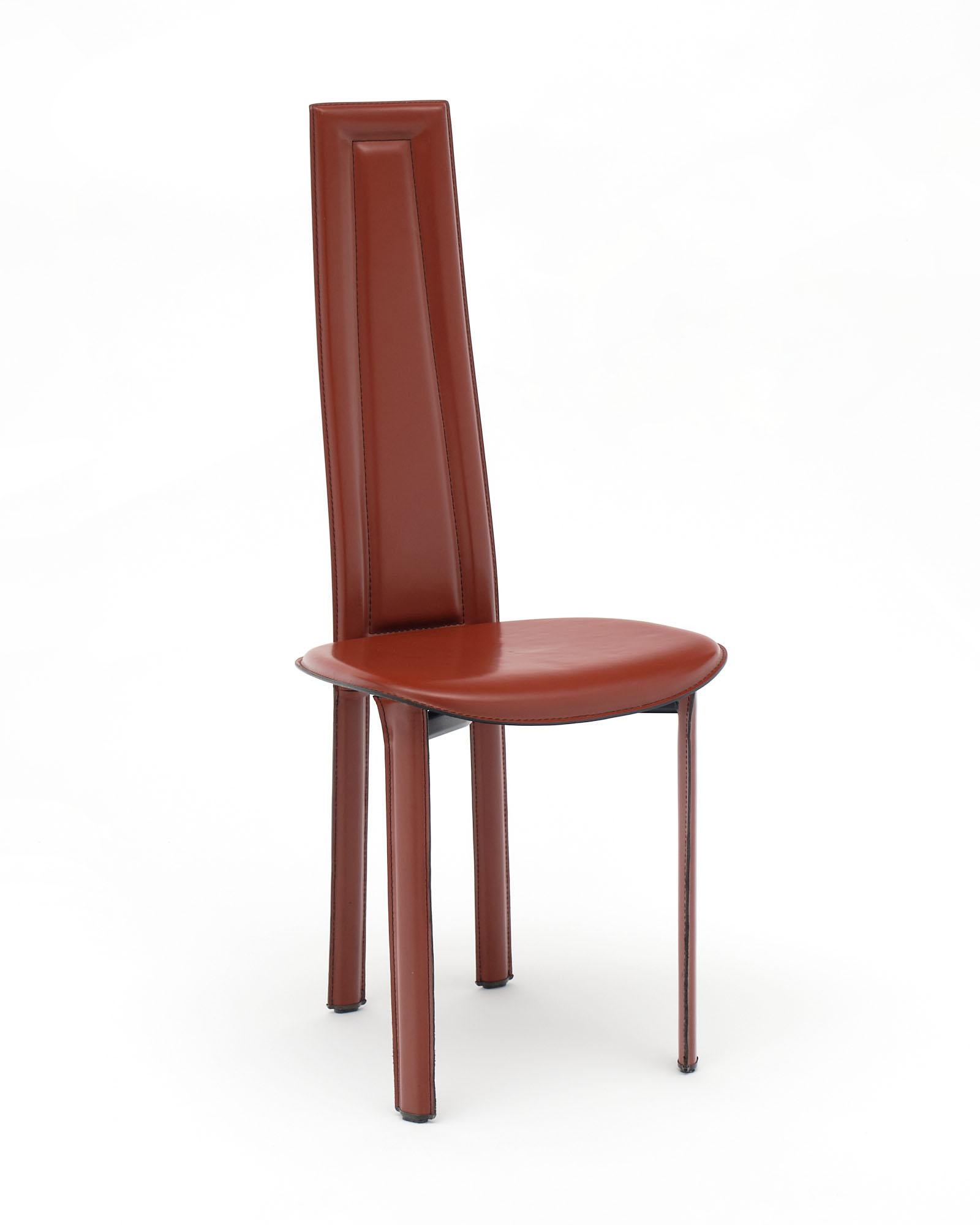Italian set of four red leather dining chairs in the manner of Italian designer Pietro Costantini. The design offers high backs and thin linear leather legs. The strong stitched leather design provides superb comfort.