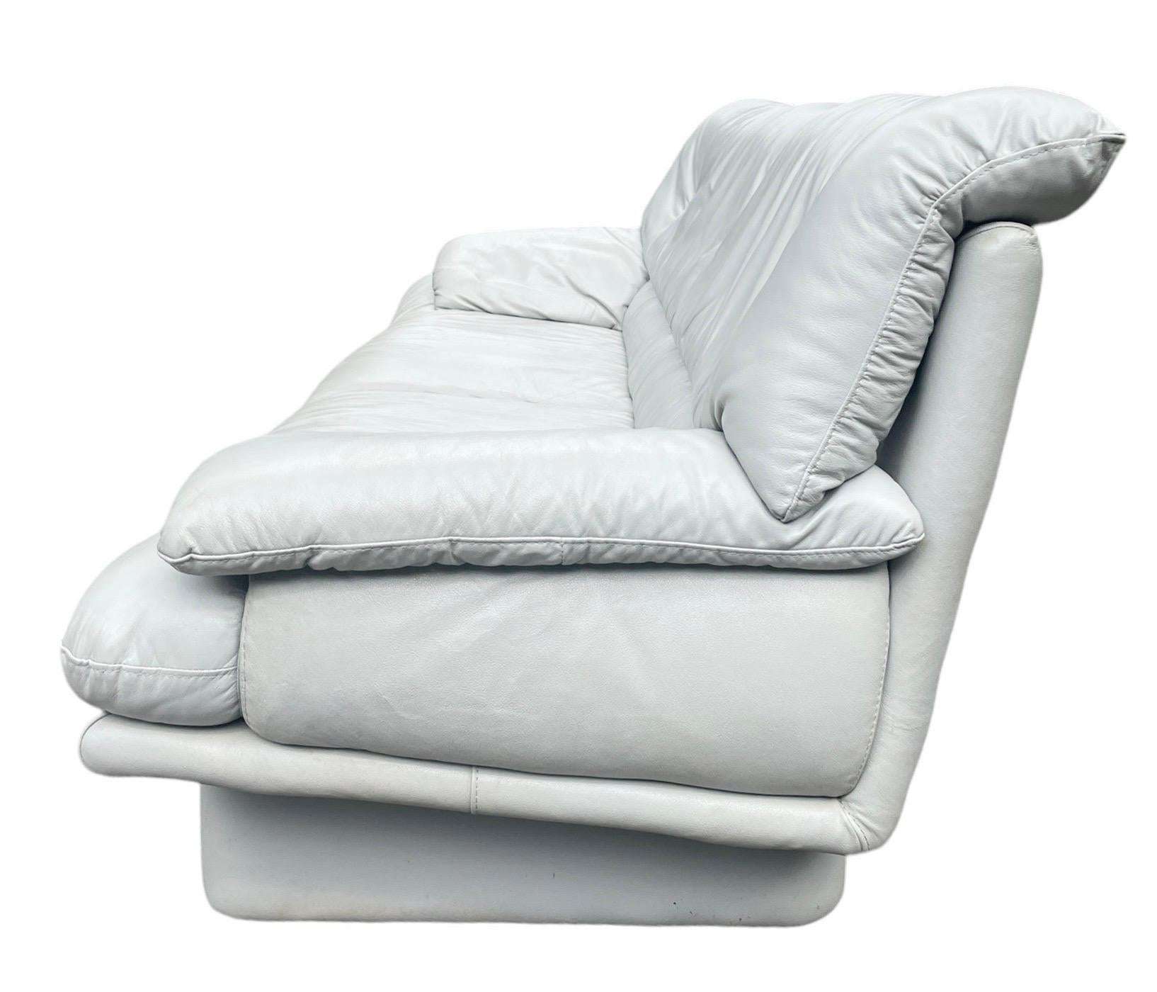 Iconic postmodern creamy gray/white 3 person sofa with a lived in charming vintage look. These are probably Natuzzi version of the Nicoletti Salotti Italian leather sofa and chair line. A statement piece in your living room or anywhere you decide to