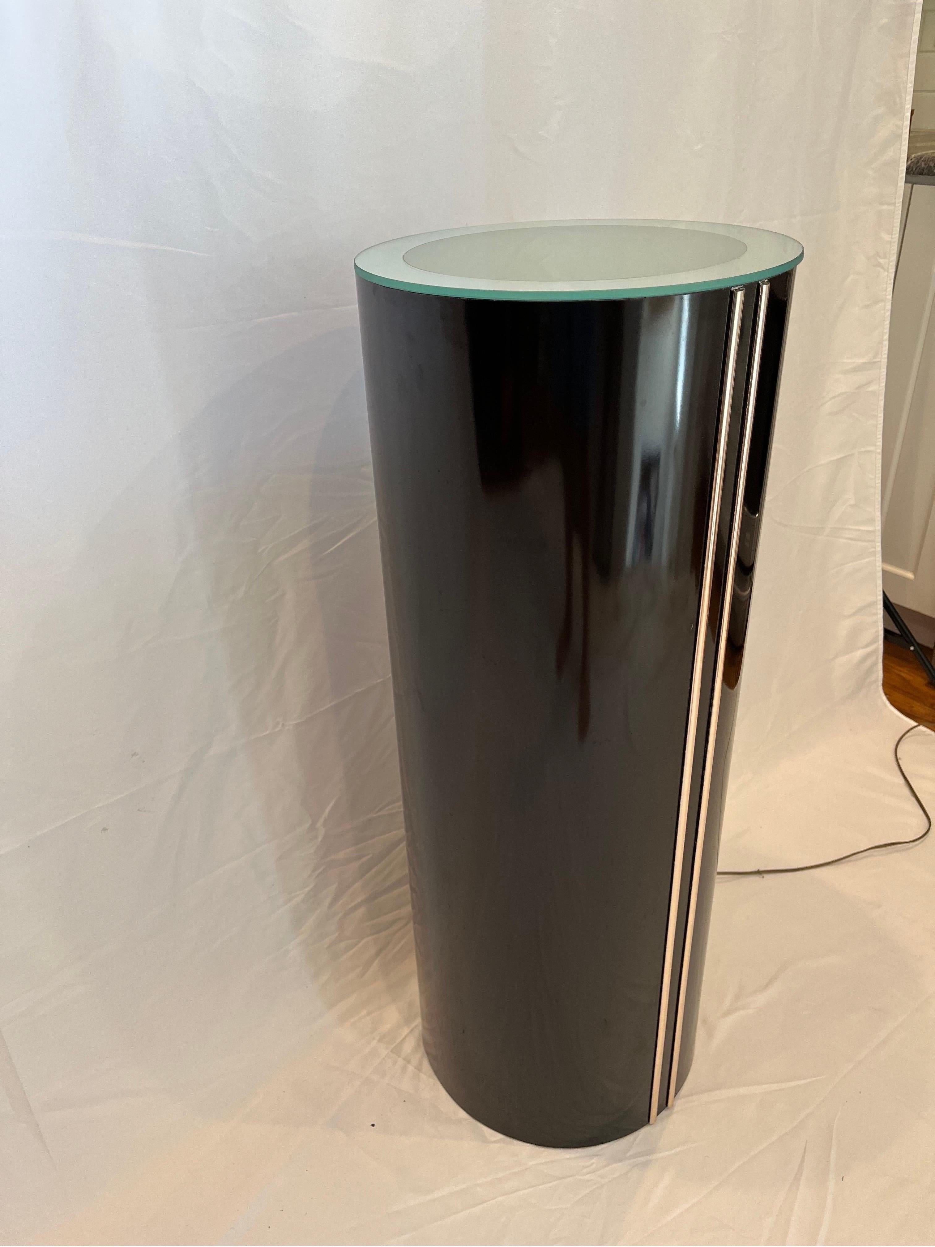 Postmodern lighted pedestal with mirror rimmed frosted glass top. High gloss black pedestal with 2 raised vertical gold accent stripes. 