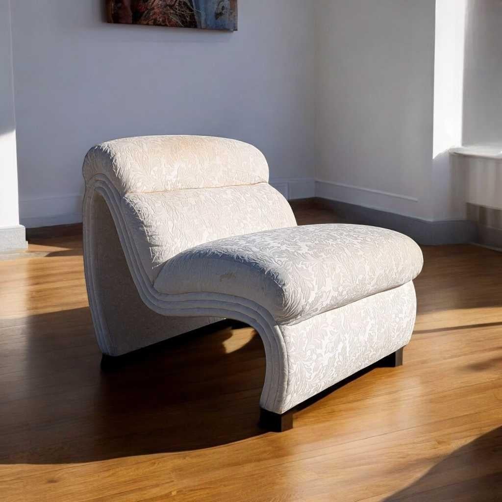 A distinctive lounge chair in the postmodern tradition, crafted with sculptural curves and showcasing floral textured upholstery. This piece blends bold design with organic lines—ideal for a living room, reading nook, or creative
