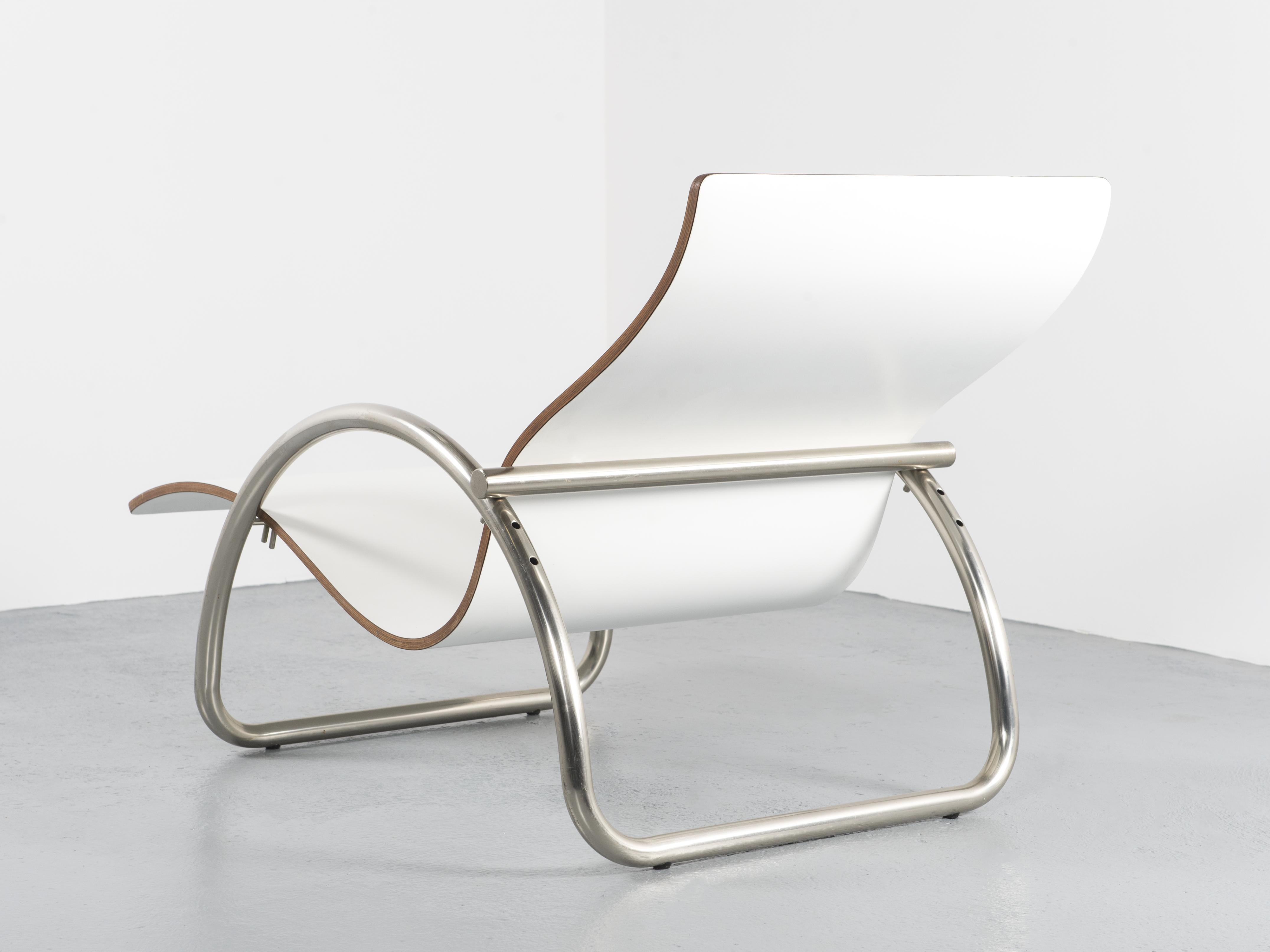 A curvaceous lounge chair from the 1980s offering 3 seating positions. 
Shell made out of one single piece of bent, laminated plywood, lacquered in white. The base is in the shape of a semi-circle in chrome-plated aluminium that both serves to