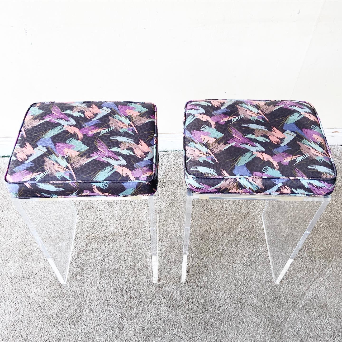 Amazing pair of 1980s postmodern lucite stool. Each stool cushion features a strokes of blue, pink, purple and green over black fabric.