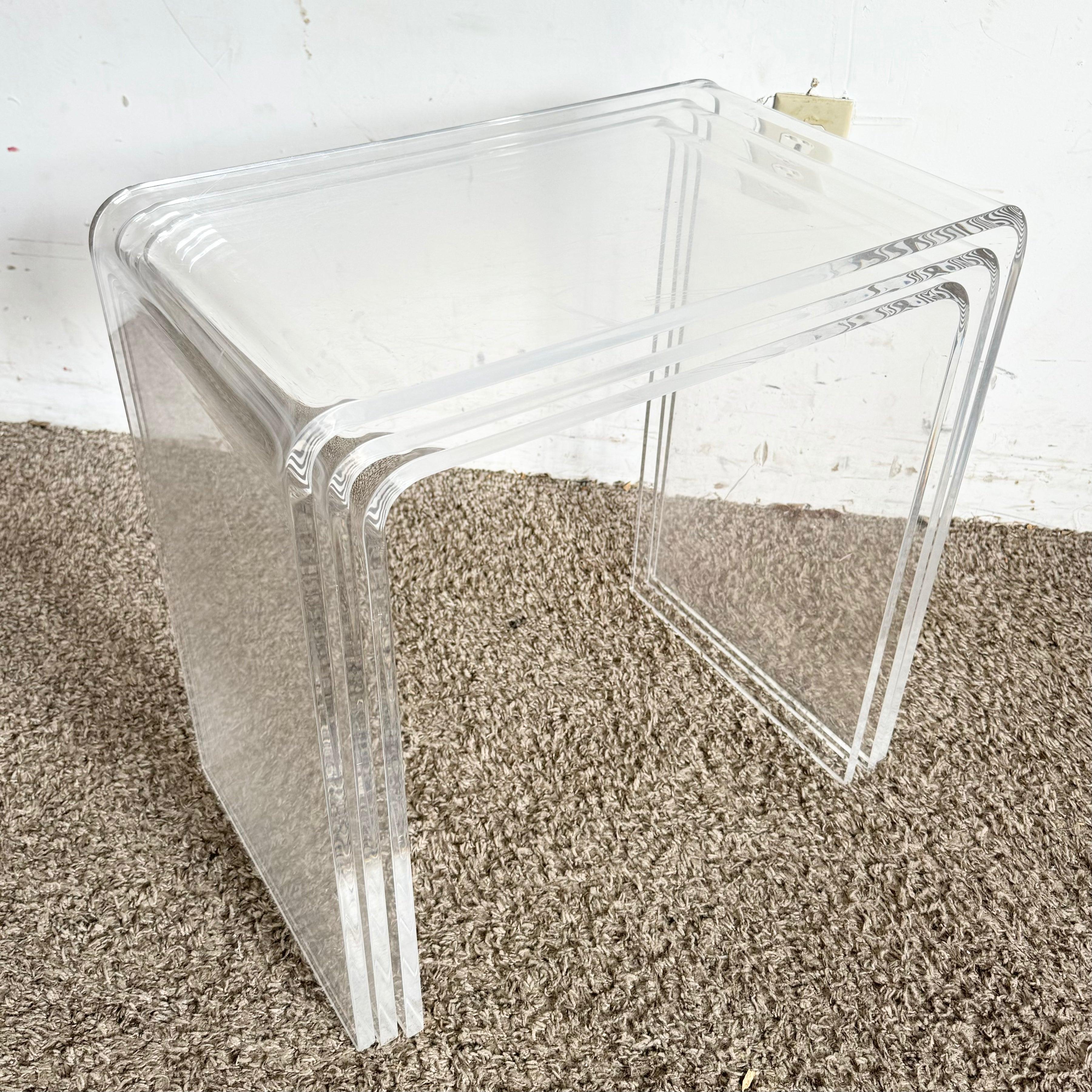 Postmodern Lucite Waterfall Nesting Side Tables, set of 3 with clear Lucite and waterfall design, ideal for modern and space-saving decor.
 
 Some scratches on the lucite as shown in the photos. We sell all items in the condition we acquire them,