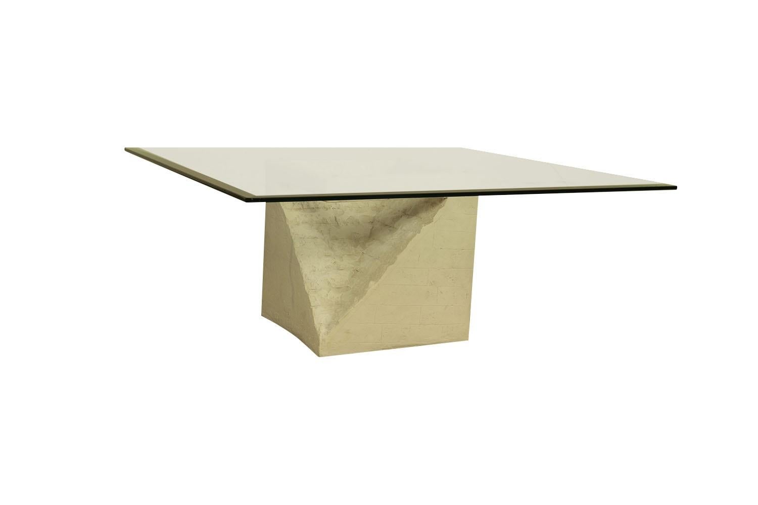 Superbe table basse postmoderne sculptée en pierre de Mactan et verre au design moderniste, élégant et luxuriant, vers les années 1970, composée d'une pierre de Mactan légère, d'un socle en bloc creux qui supporte le verre épais. Cette magnifique