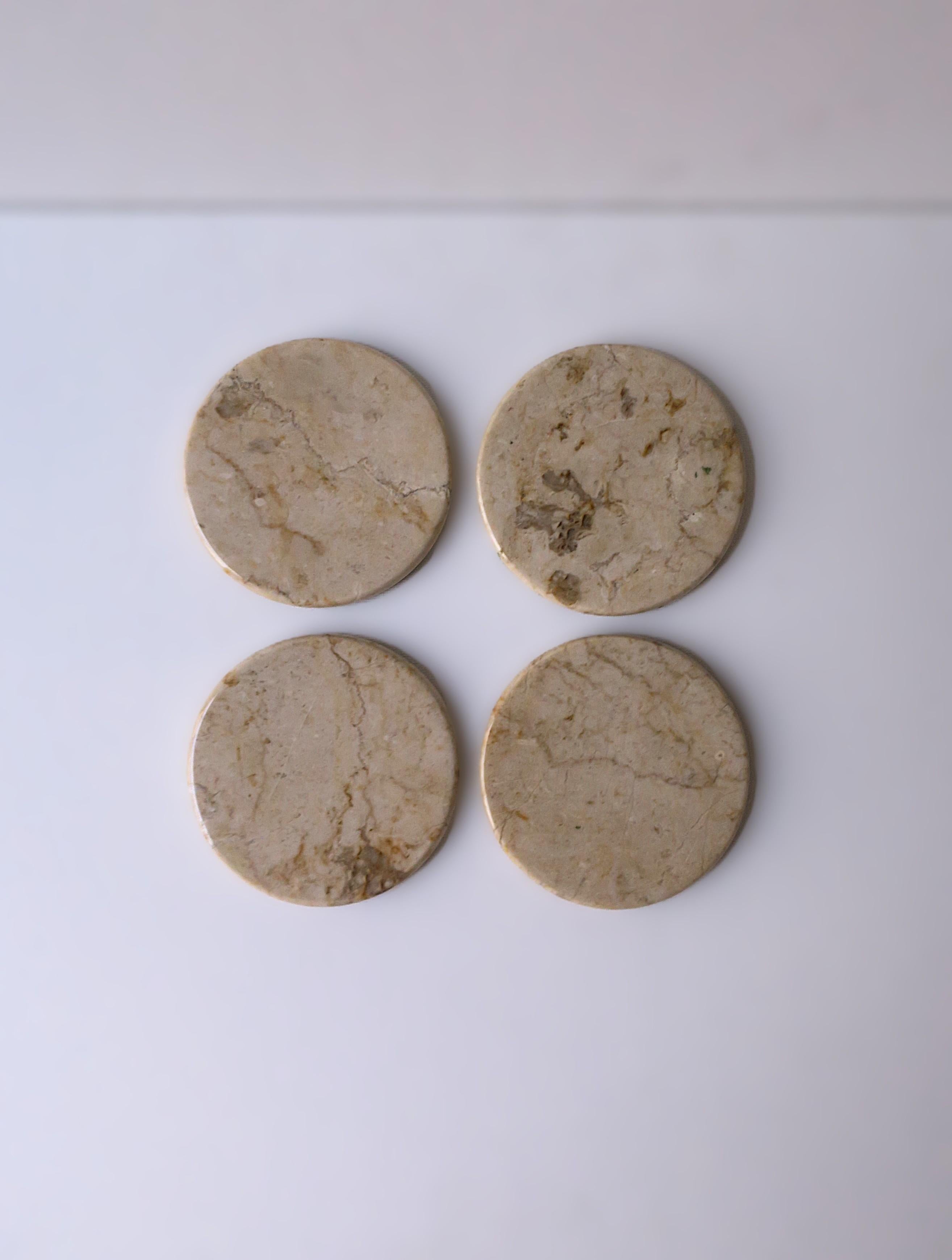 A set of four (4) '80s Post-Modern period marble drinks cocktails coasters, circa late-20th century, 1980s. Coasters are a natural creamy beige marble stone with polished surface and round soft edge. A great addition to any bar, bar cart, or