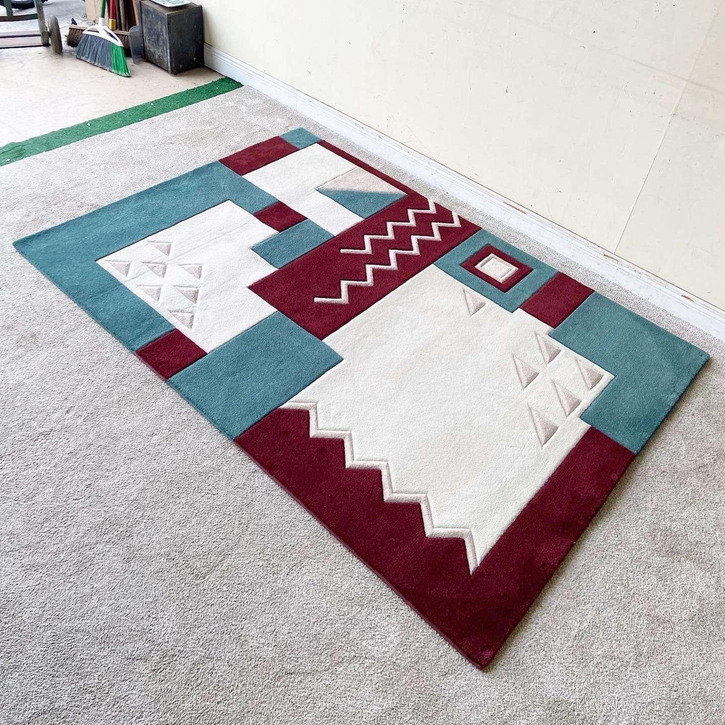 Exceptional vintage postmodern area rug. Features a tessellation of maroon and blue shapes with beige and off white sections embedded with triangles and zig zigs.

Rug 1
