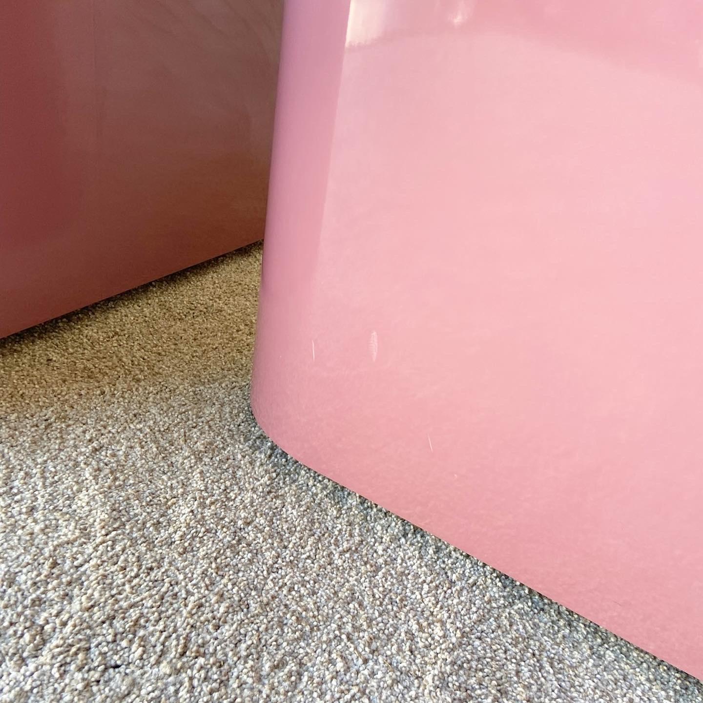 Sensational pair of vintage 1980s postmodern triangular tables on wheels. Each feature a mauve pink lacquer laminate.

Shorter table has a height of 13.75”.