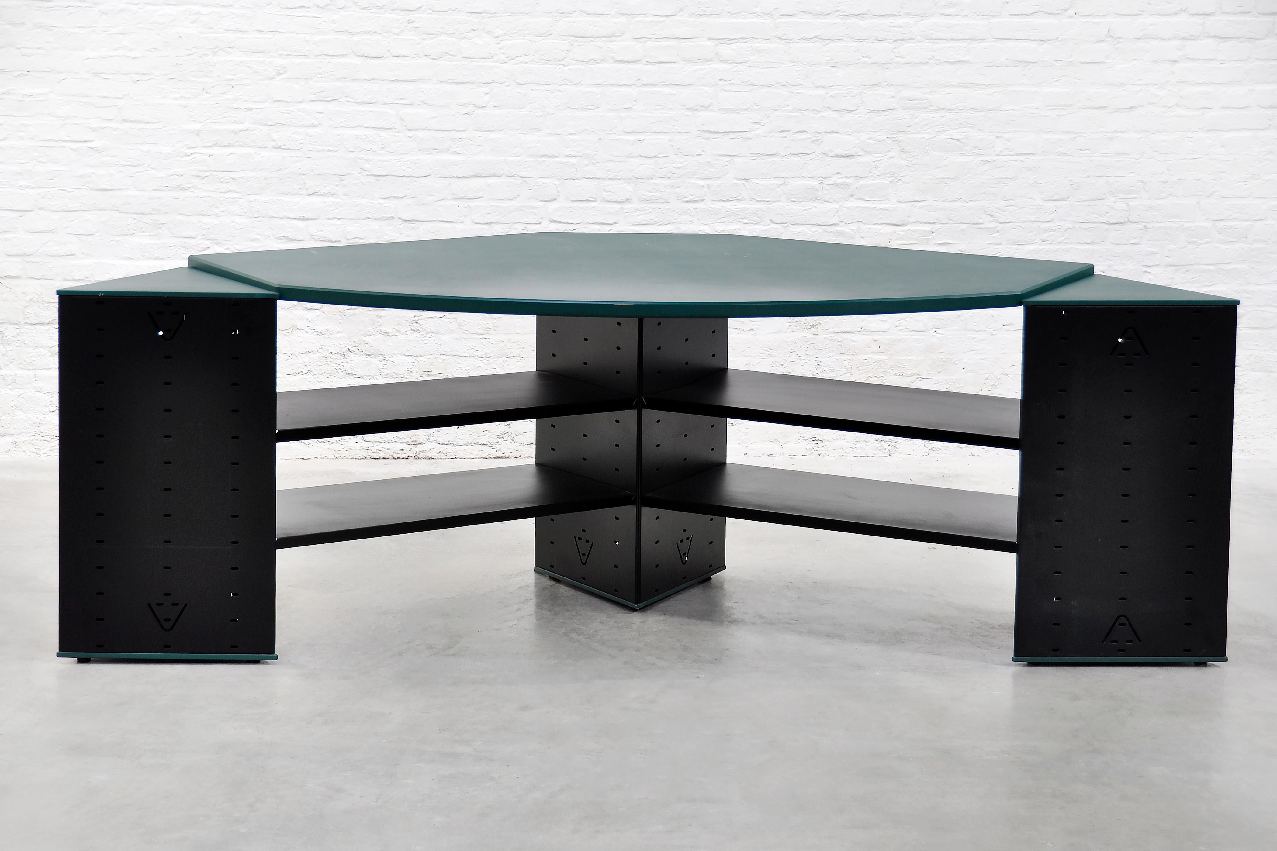 Este llamativo escritorio postmoderno ejemplifica la atrevida estética del movimiento de diseño Memphis. El escritorio presenta una superficie asimétrica de madera laminada verde apoyada en una estructura de acero negro con estantes, que crea una