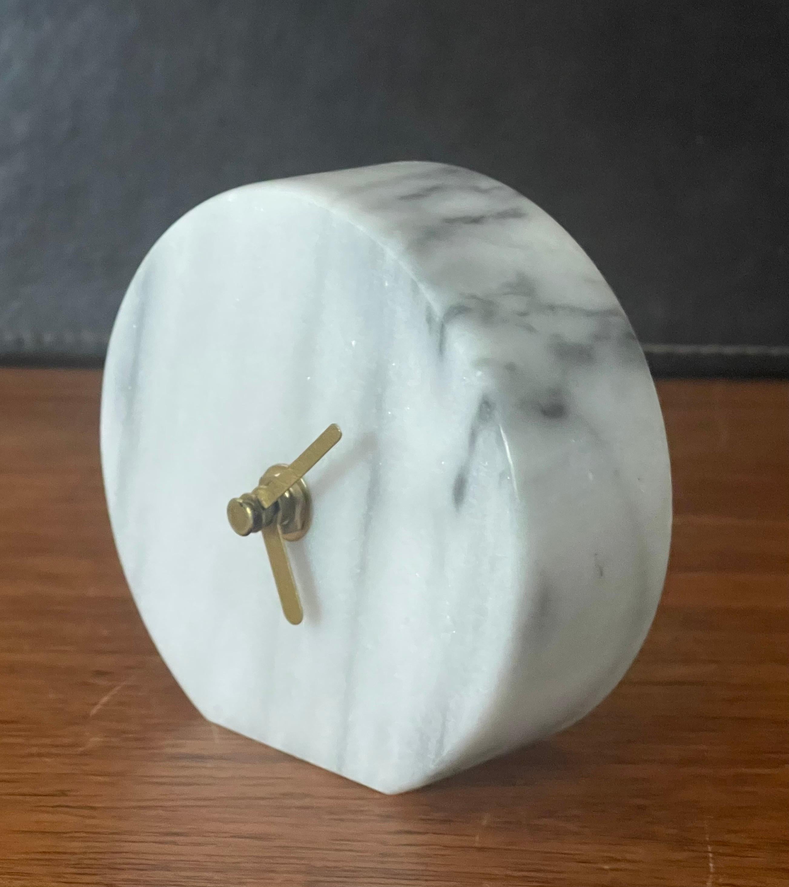 A very cool postmodern / Memphis era solid white marble desk clock with brass hands, circa 1980s. The piece has a great minimalist look and is in very good condition with no chips or cracks. It is battery-operated quartz movement and measures 4.5