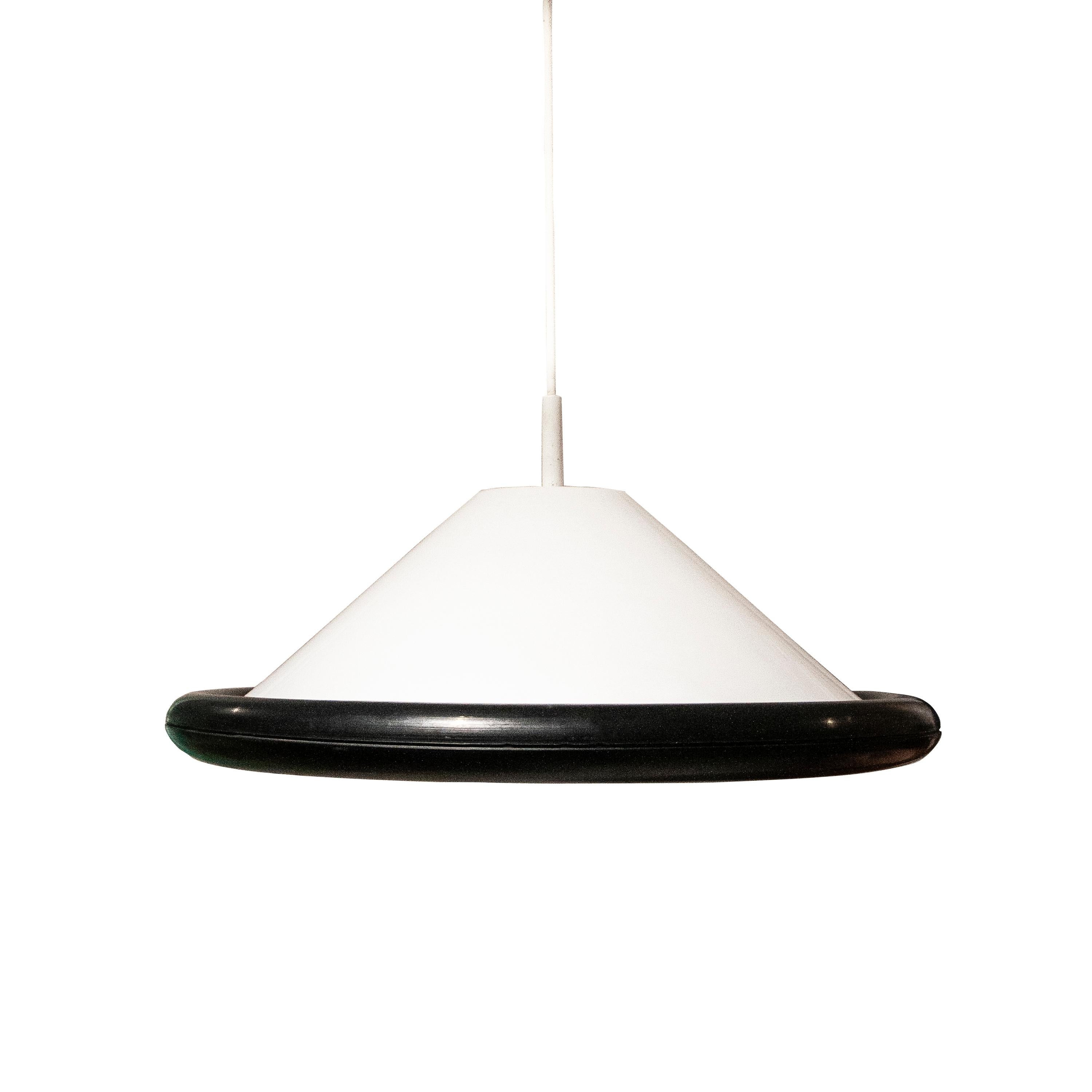 White Memphis-Style pendant lamp. The lamp is composed of a semi translucent conic top and the opaque base, with geometry of superimposed concentric circles, is made of white lacquered metal. The edge and the cup are made of flexible black rubber.