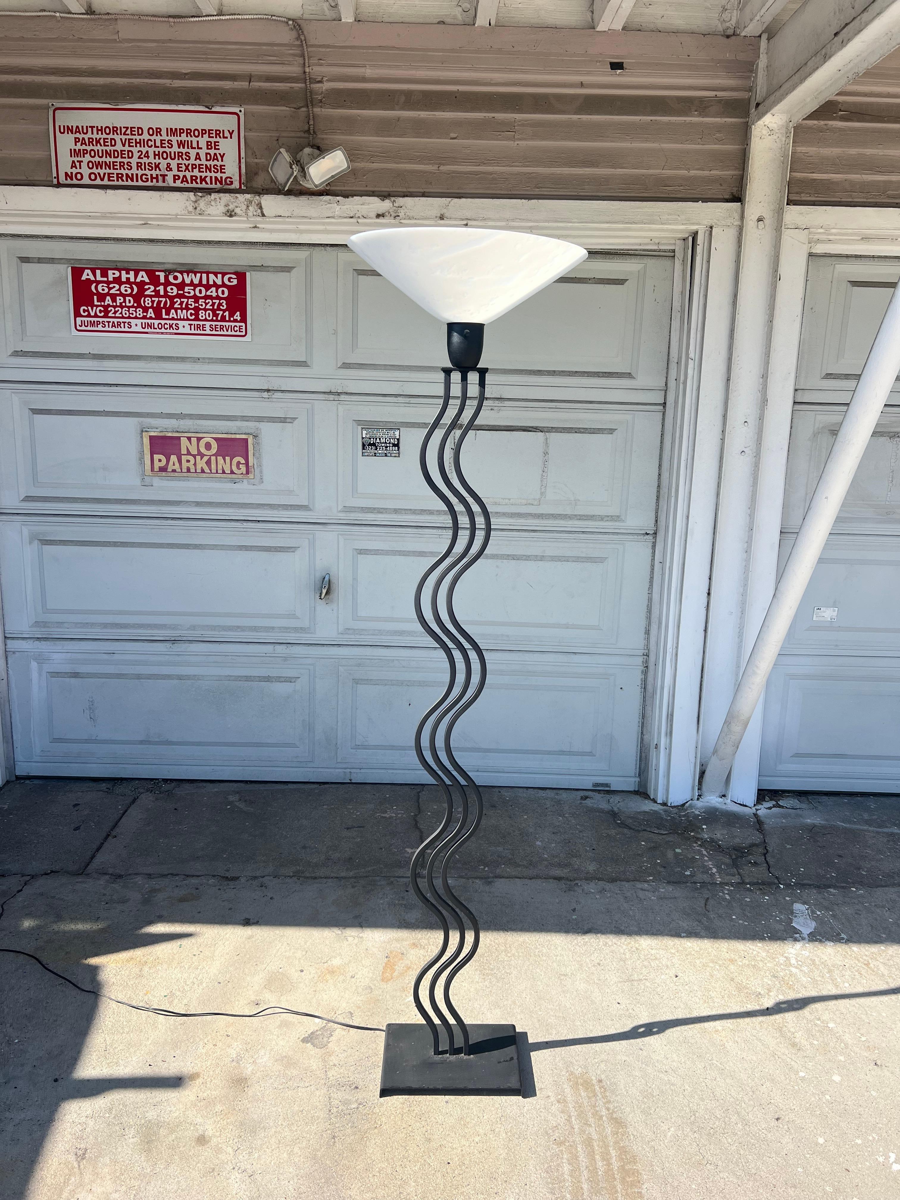 Three parallel black tubular bars form a wavy squiggle on this 80's table lamp. Matte black coated stems attached to a rectangular base. Some minor paint scrapes have been touched up, but overall excellent vintage condition. Comes with the original