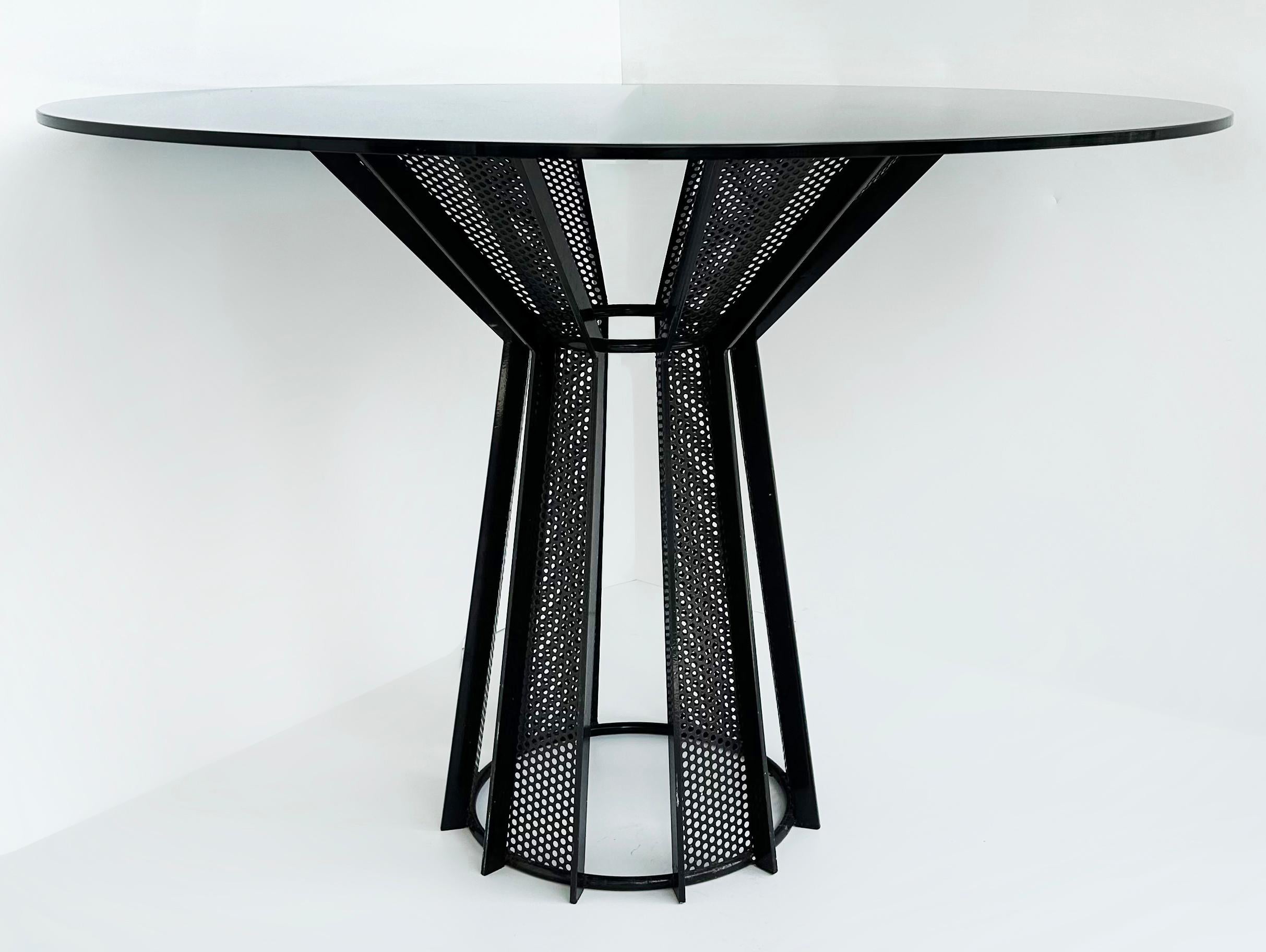 

Postmodern Metal and Smoked Glass Dining Table

Offered for sale is a small postmodern dining table that seats four comfortably. This architecturally designed table has a round smoked glass top that sits on a black angular round base. The base is