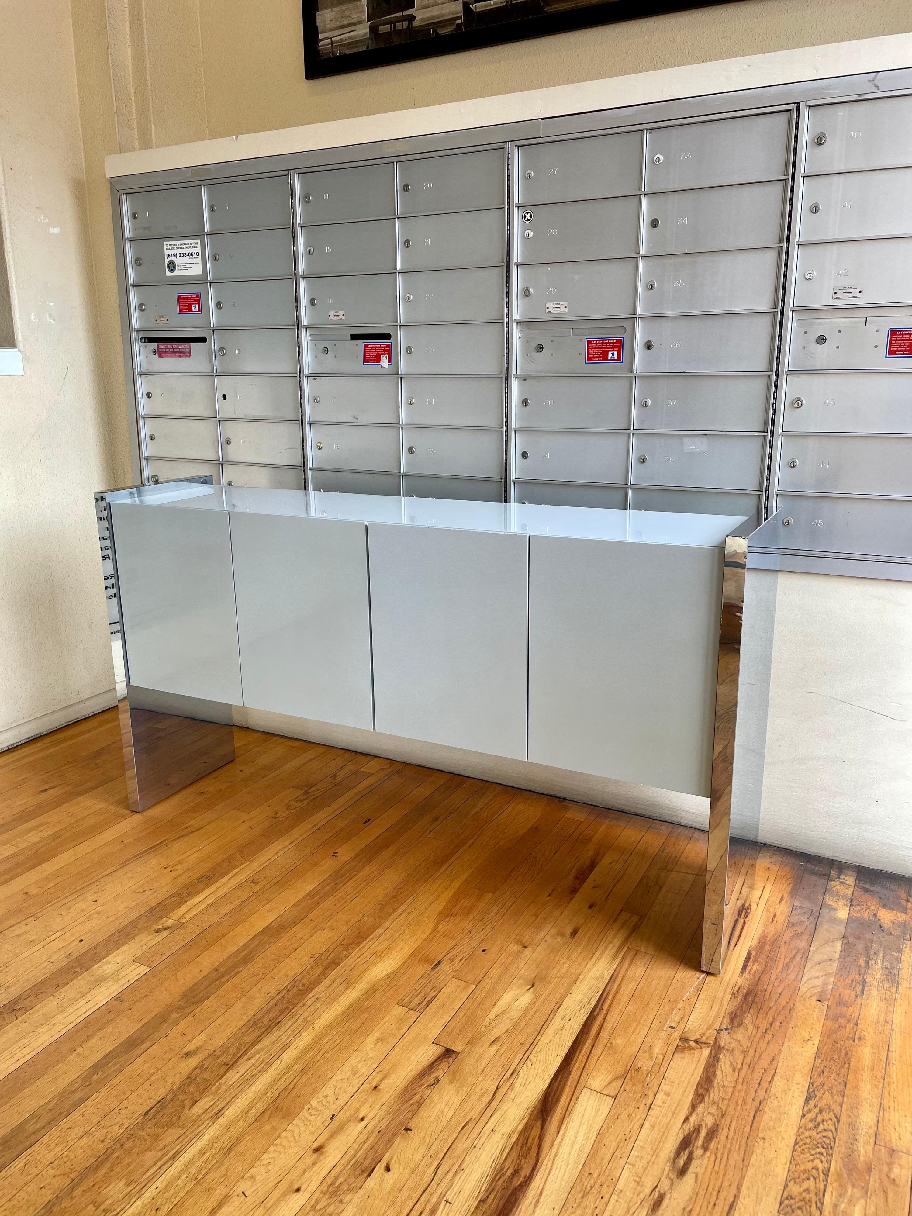1980's light grey postmodern credenza designed by Milo Baughman for Thayer Coggin, with chrome sides the piece its sold AS/IS condition, some chips on the paint and cracking on the finish as shown looks ok, but when you look closer some