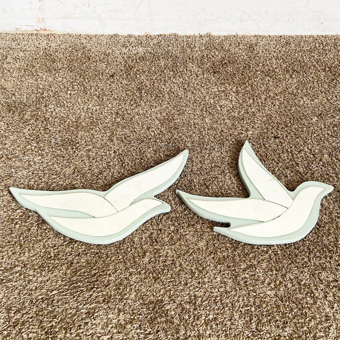 Dive into the world of Postmodern design with this Mirrored Birds Wall Art Pair. Each piece showcases a delicate baby blue bird, adorned with three mirrored segments that play with light and reflection. Beyond their aesthetic appeal, these birds