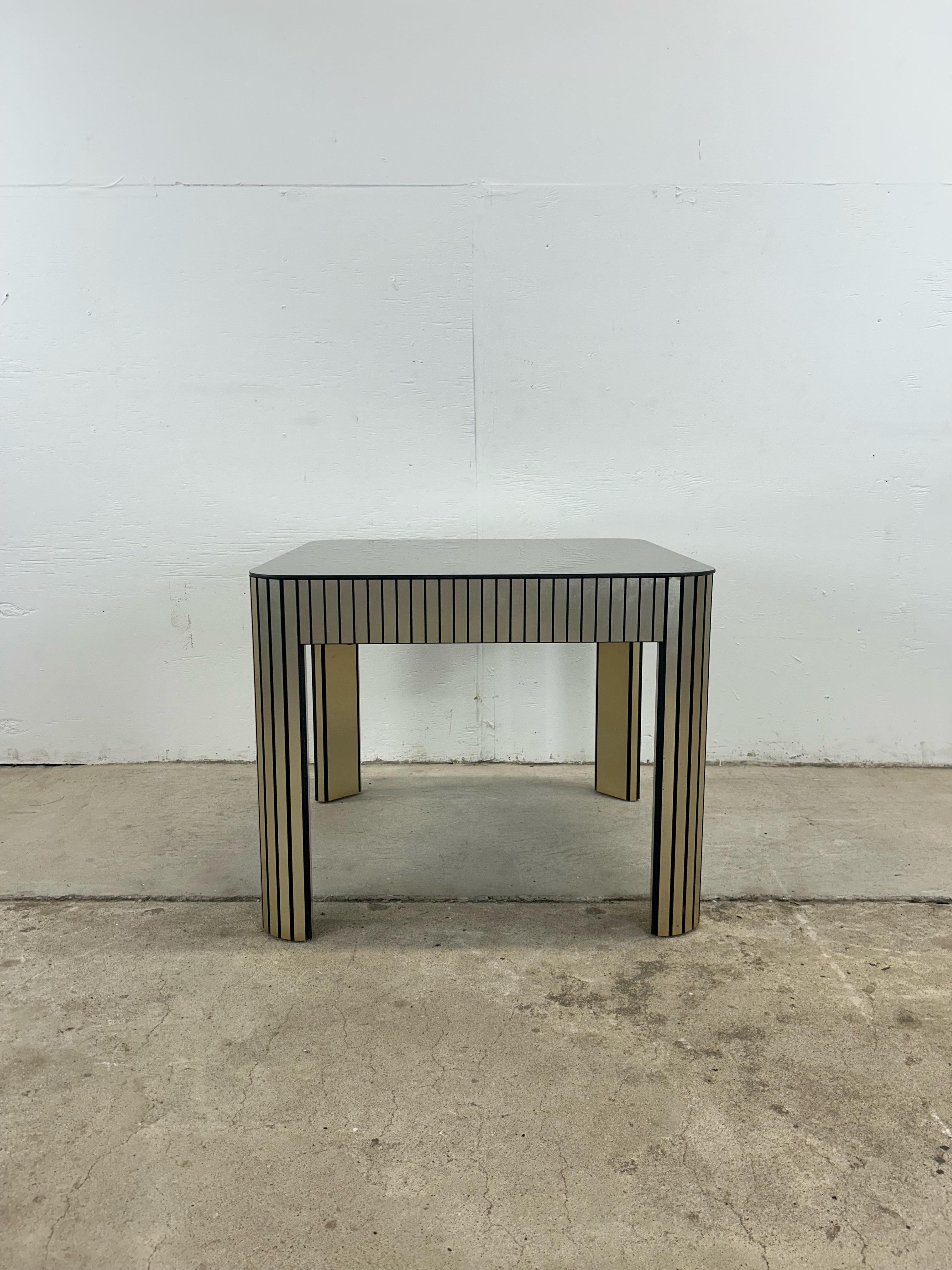 This postmodern end table features chrome accented sides and mirrored glass top.   Matching coffee table available separately.
 Dimensions: 25.25w 25.25d 20.5h 

Condition: Mirrored glass top has one area with some wear (see photos) but overall