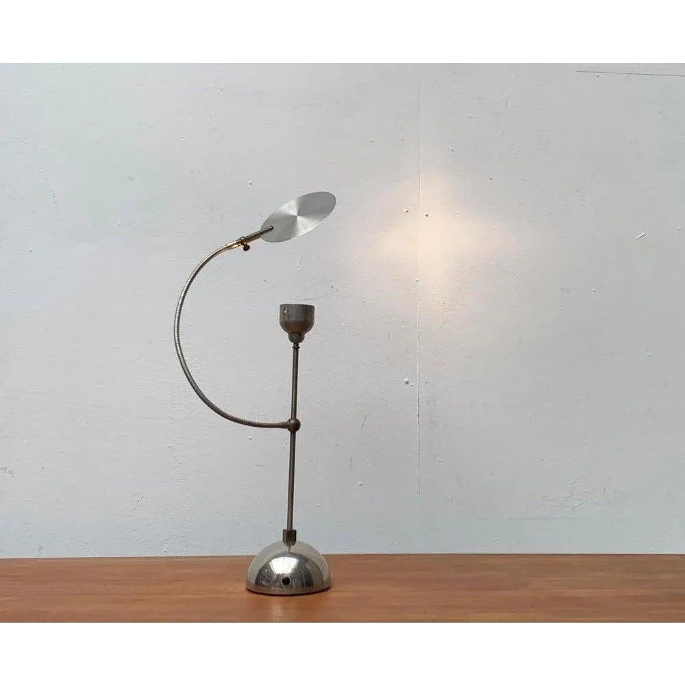 Lámpara de mesa muy rara del fabricante italiano Catellani & Smith de la colección Oggeti Senza Tempo de 1989.

Un diseño posmoderno con una nota juguetona. Con sus elementos flexibles, la lámpara parece un personaje animado. Un elemento recurrente