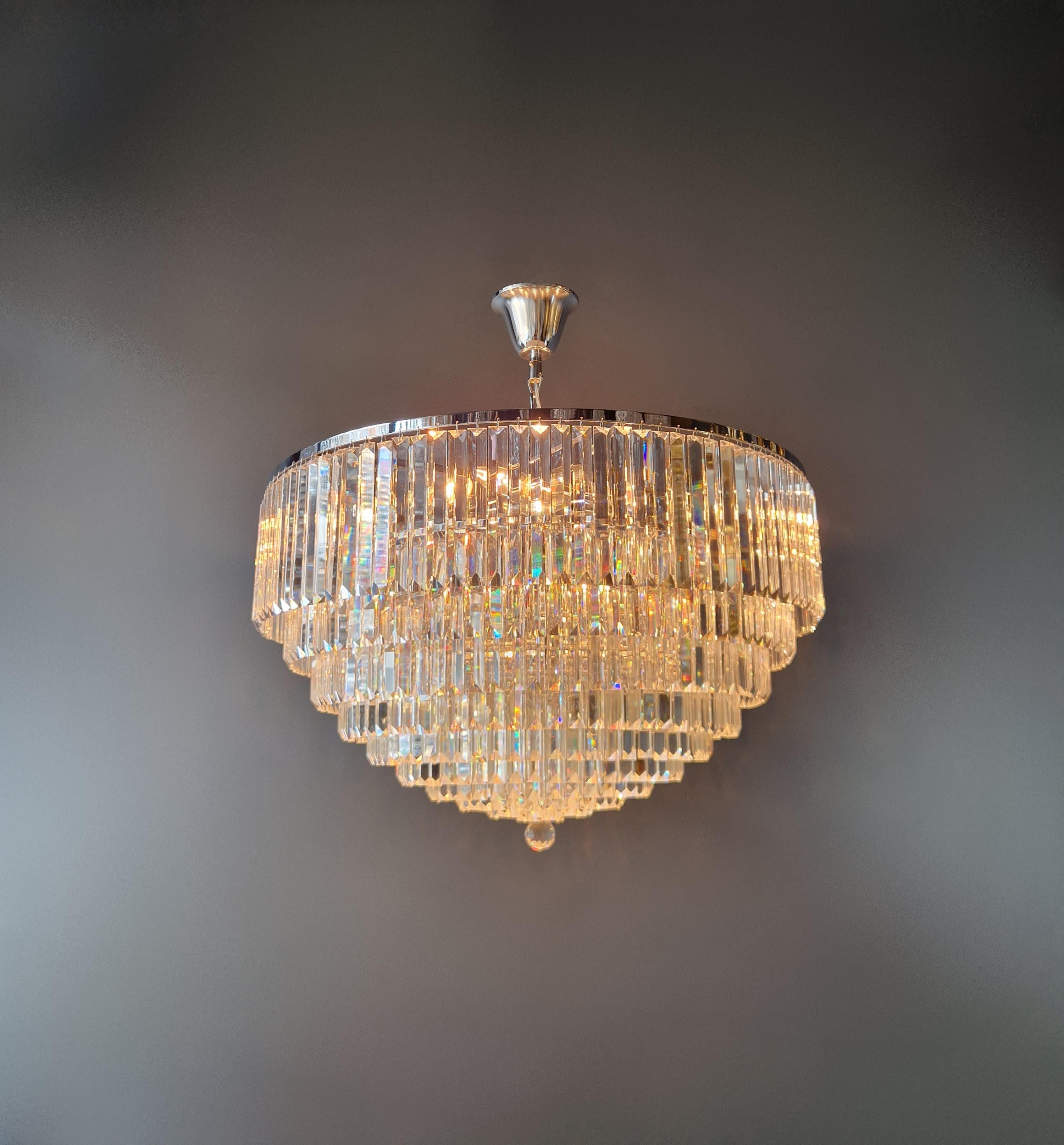 Immerse yourself in the fascinating world of postmodernism and experience pure elegance with our breathtaking silver/chrome chandelier decorated with crystals. This work of art of lighting makes a statement in any room and gives your interior an