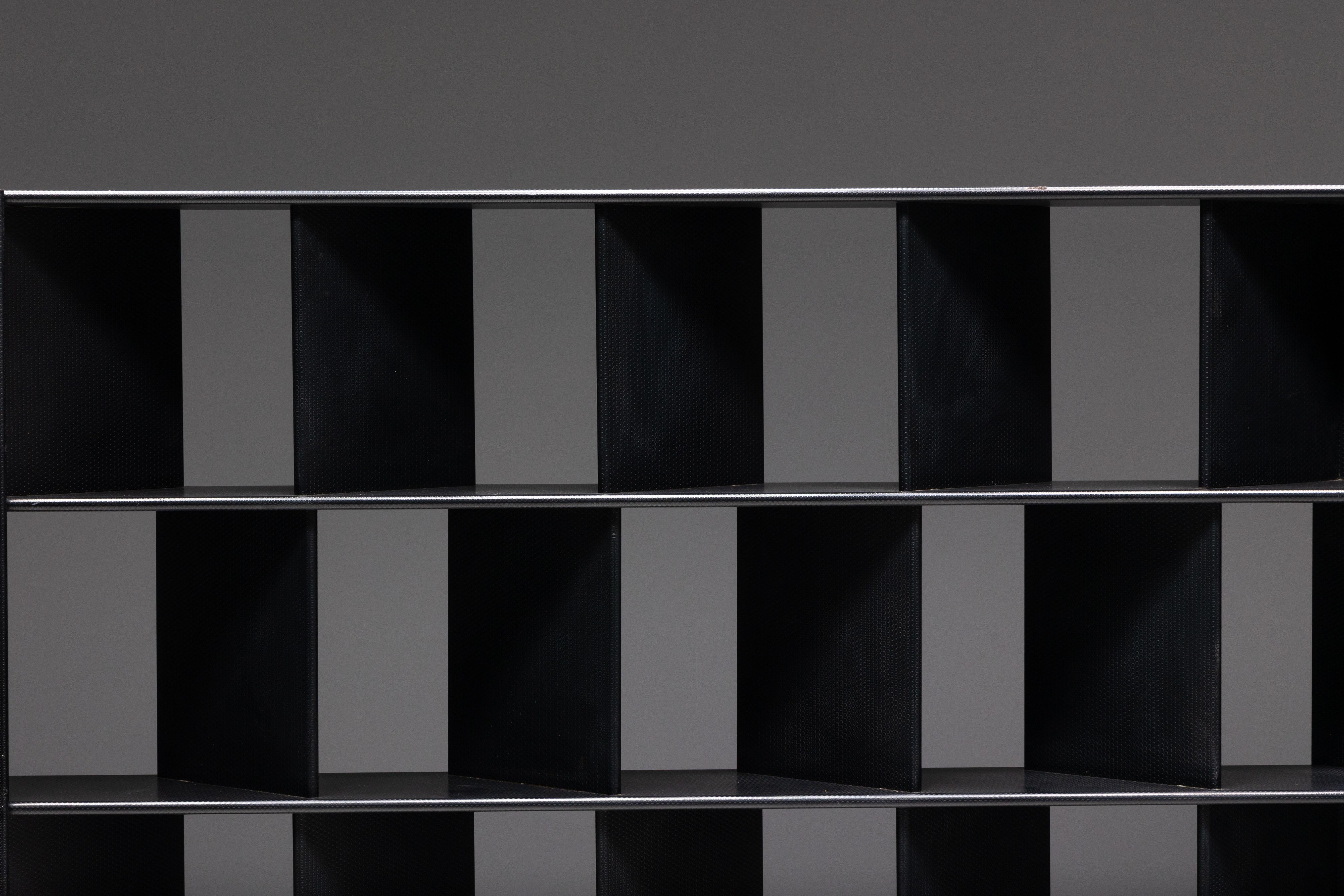 Dieses markante schwarze Bücherregal aus den 1980er Jahren verkörpert die kühne Ästhetik der postmodernen Designbewegung. Seine modulare Gitterstruktur ist sowohl funktional als auch skulptural und bietet 24 quadratische Fächer, um Bücher zu ordnen,