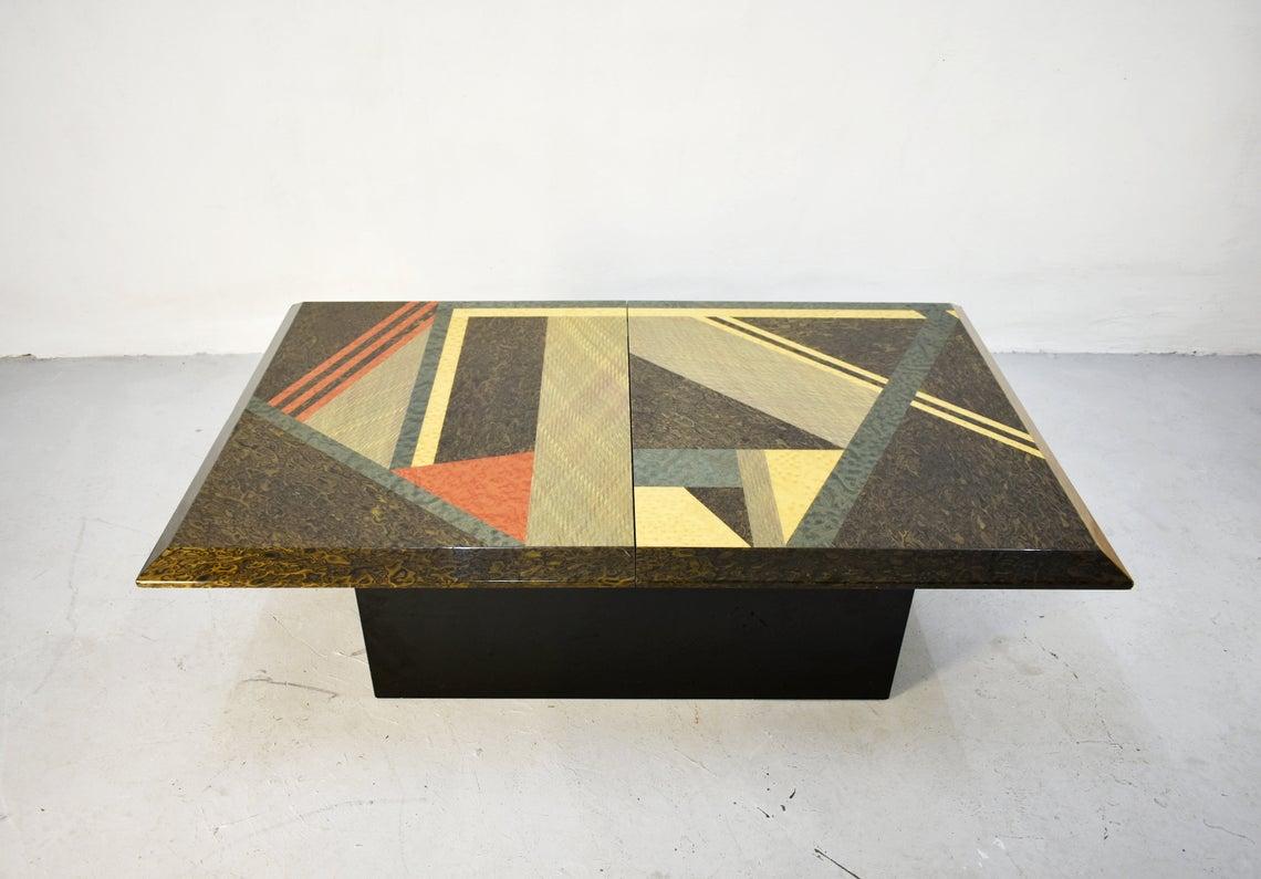 Italian coffee table from the 1980s with an extendable tabletop. When extended it reveals a hidden mirrored storage space (a dry bar)

Designed by Giovanni Offredi and produced by Saporiti.

The base of the table is made of black lacquered wood.