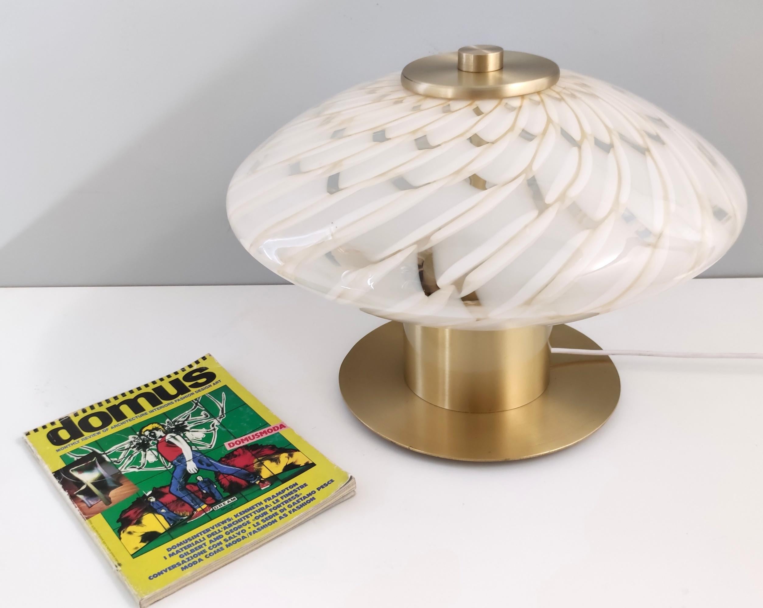 Made in Italy, 1980s. 
This table lamp is made in Murano glass and brass.
It is a vintage piece, therefore it might show slight traces of use, but it can be considered as in perfect original condition and ready to give ambiance to any room.