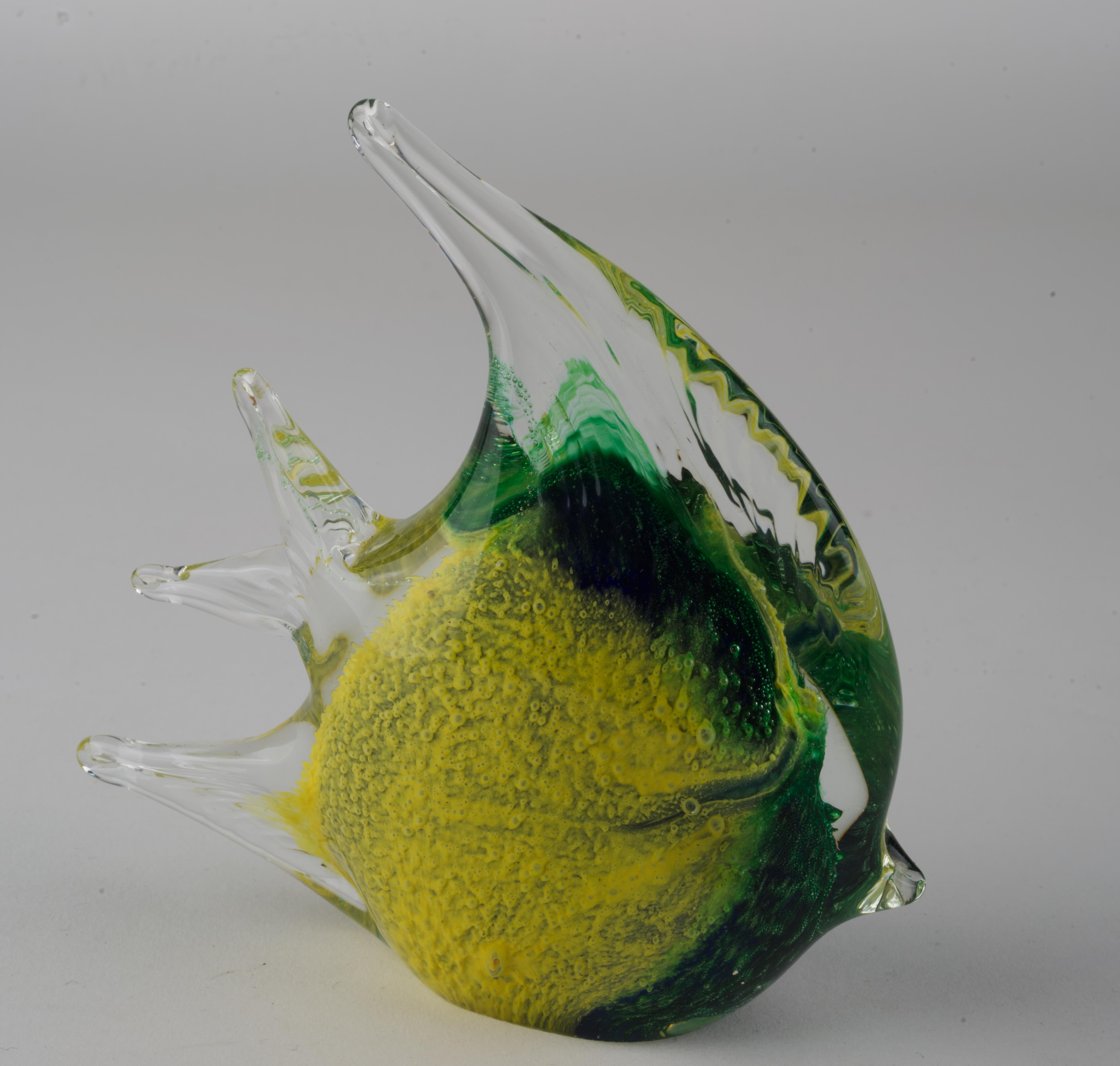 Festive green and yellow tropical fish figurine or paperweight is made in sommerso technique; colored glass gather, dipped into pigments, is cased over with clear glass. Controlled bubbles are used to give the piece animation and movement, accenting