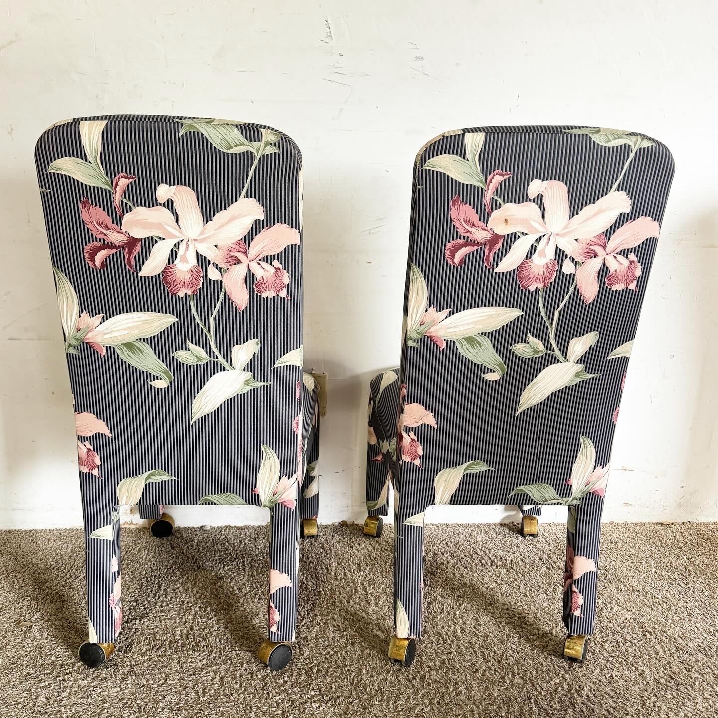 Revitalize your space with this set of four Postmodern Navy Blue Pinstripe and Pink Hibiscus Parsons Chairs on Casters. These chairs blend a classic navy blue pinstripe design with vibrant pink hibiscus accents, creating a unique, stylish look.