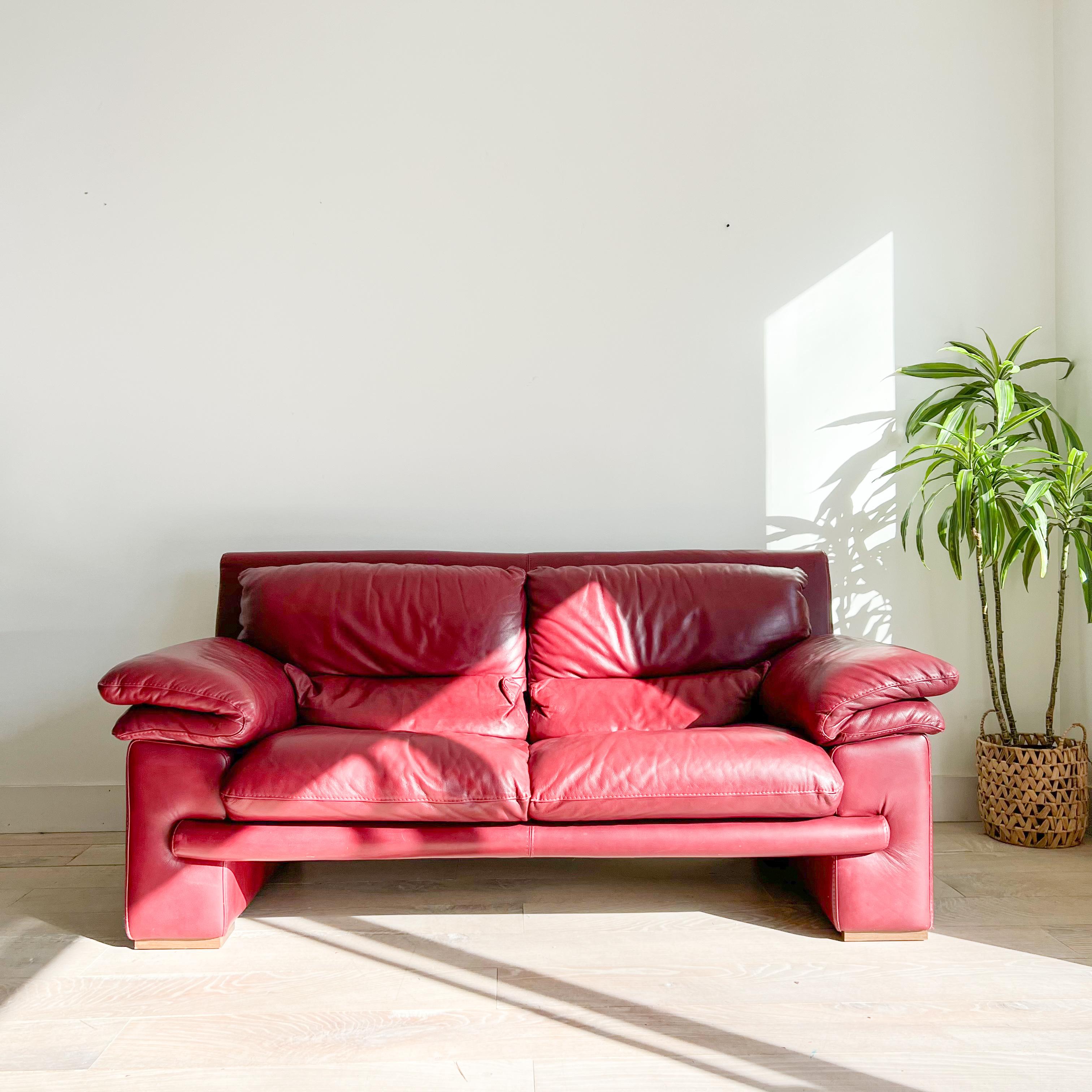 Elevate your living space with this exquisite postmodern Nicoletti dark red leather sofa, expertly crafted in Italy. Boasting timeless elegance and superior comfort, this sofa is sure to become the focal point of any room.

The rich dark red leather