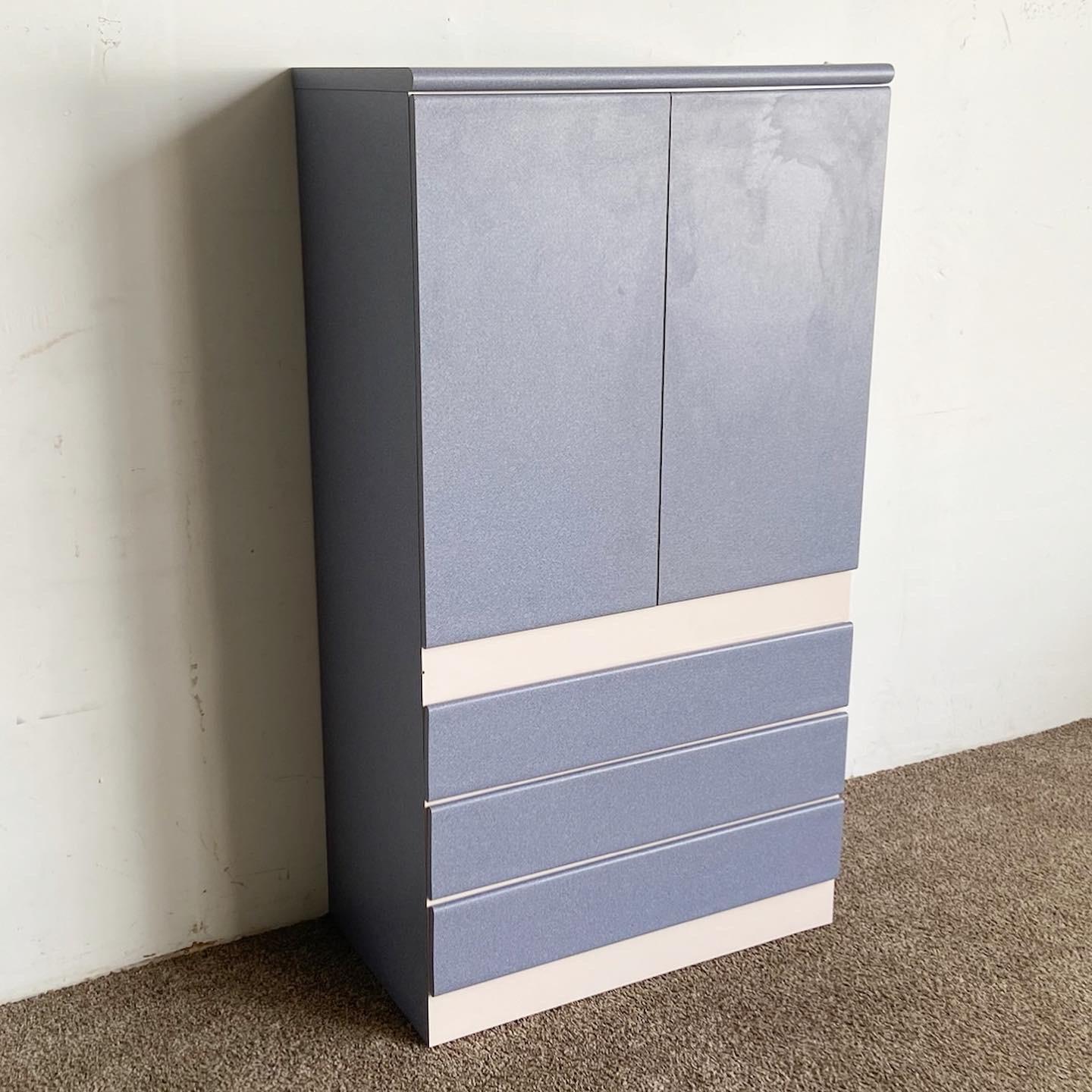 Introduce a touch of the tranquil seascape into your space with our Postmodern Ocean Spray Laminate Armoire. Its vibrant palette of blue and off-white is subtly accentuated with faux shimmers of pink and purple. This striking piece, crafted with