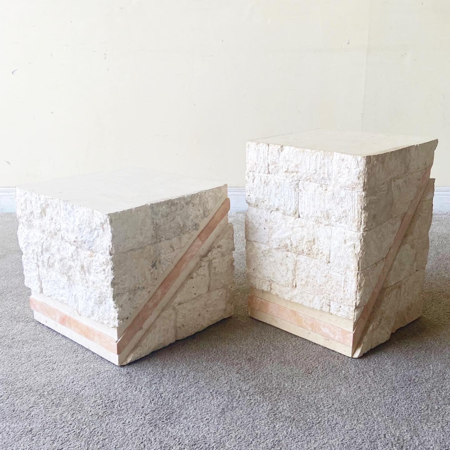 Exceptional pair of postmodern tessellated stone side tables. Each display a beige tessellated limestone with a polished pink strip of tessellated stone across each face of the table sides.

Taller measures 14.5”W, 15.25”D, 21.25”H
Shorter