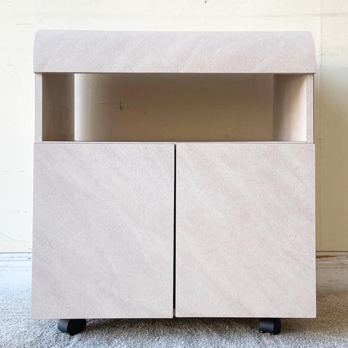 Exceptional vintage Postmodern waterfall cabinet on casters. Features a pink and lavender wash laminate with two cabinet doors which open to reveal ample storage.