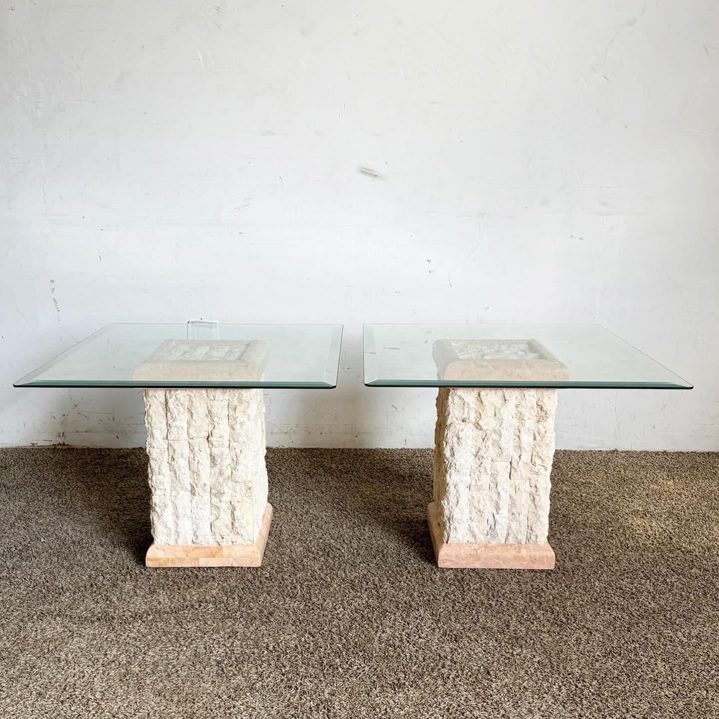 The Postmodern Pink and Beige Tessellated Stone Beveled Glass Top Side Tables, a pair, offer a unique blend of art and elegance. With bases made of tessellated stone in pink and beige, they create a captivating pattern. The beveled glass tops add