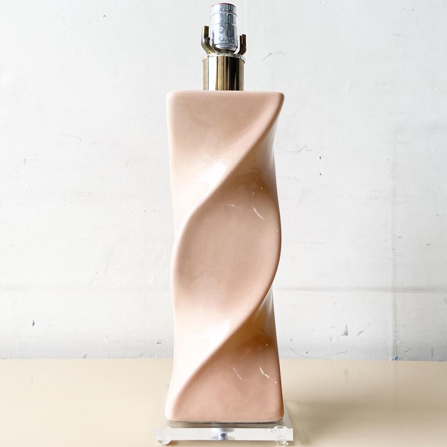 Outstanding vintage postmodern ceramic table lamp. Features a pink glass finish over the twisted rectangular body.

3 way lighting.