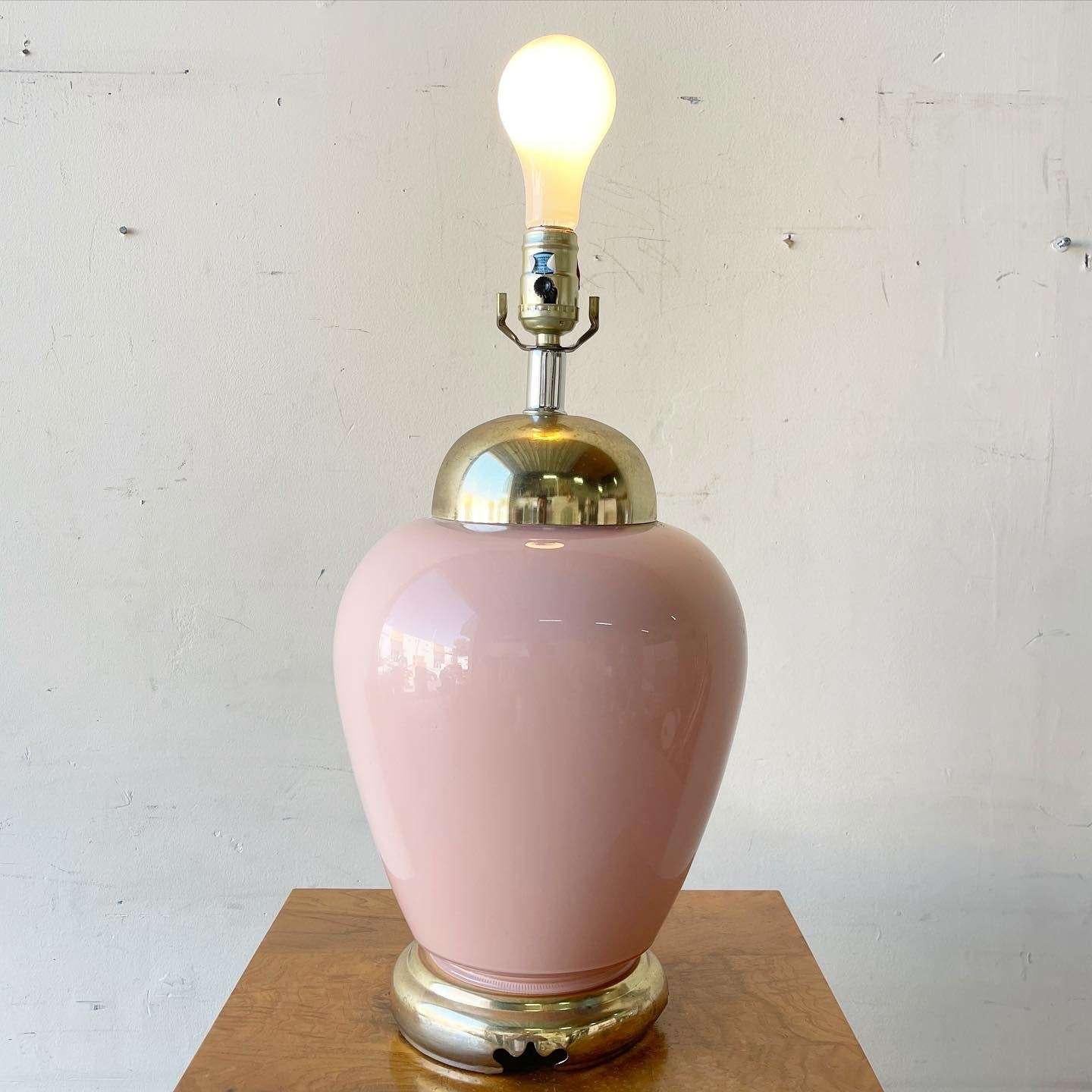 Exceptional vintage postmodern table lamp. Features a pink glass body on a gold base.
