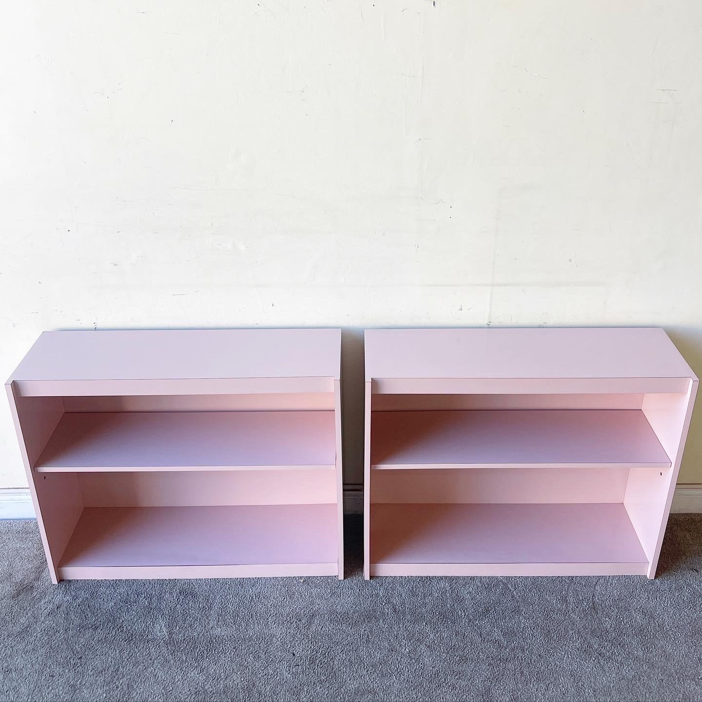 Amazing pair of postmodern bookshelves. Each feature a pink lacquer laminate and one central shelf.
 