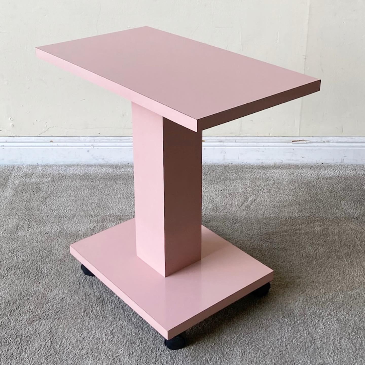 Amazing 1980s postmodern side table/cart. Features a pink lacquer laminate and site on 4 wheels.
 